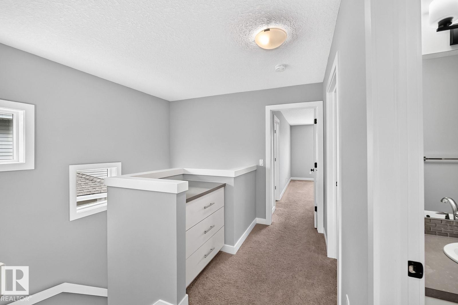 Upper-level hallway featuring neutral gray walls, carpet flooring, and white trim - 1112 176 Street Sw, Edmonton, AB - Indoor Photo Showing Other Room