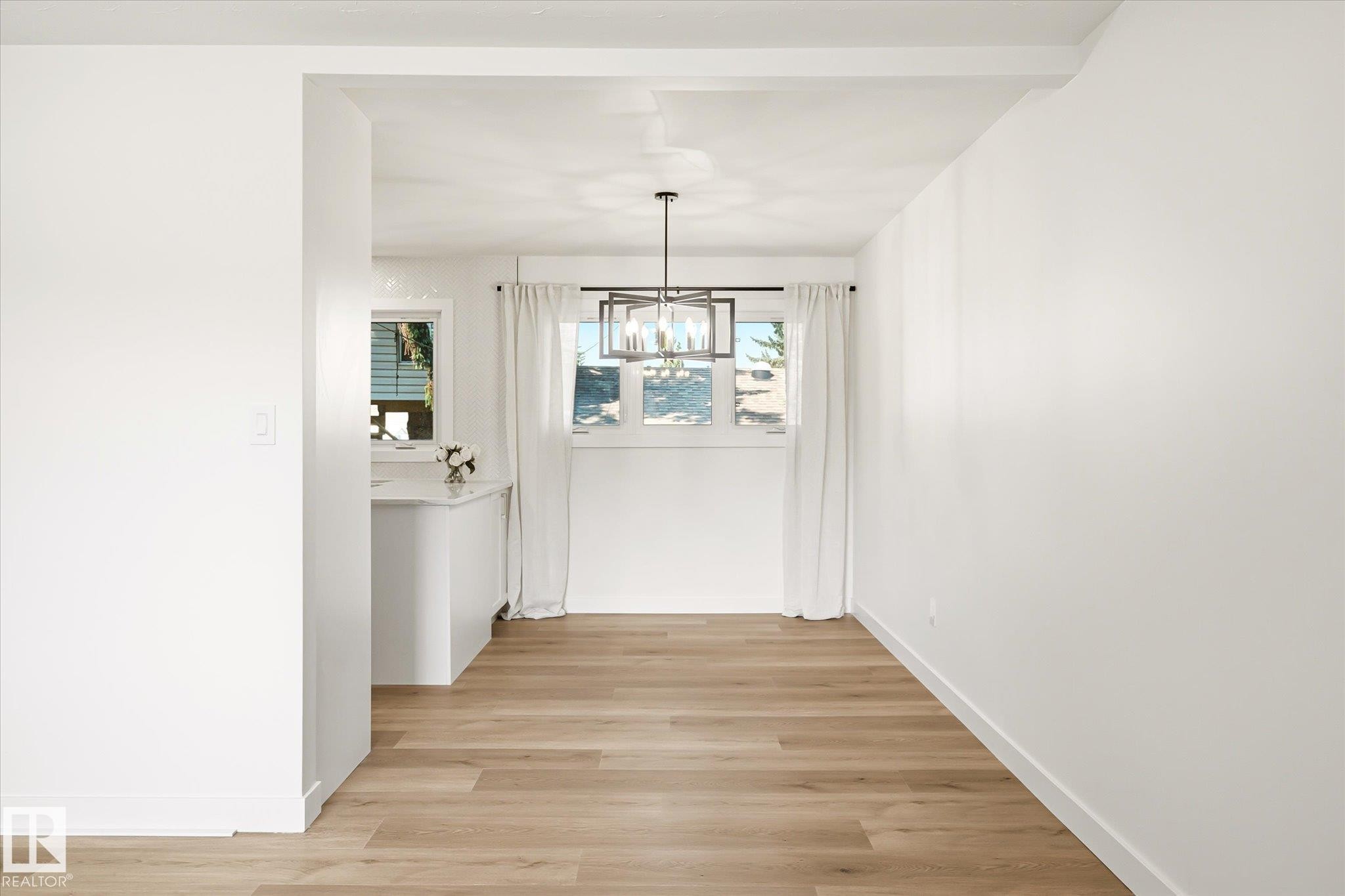 Open concept interior featuring light wood-finish flooring - 4708 104A Avenue Nw, Edmonton, AB - Indoor Photo Showing Other Room
