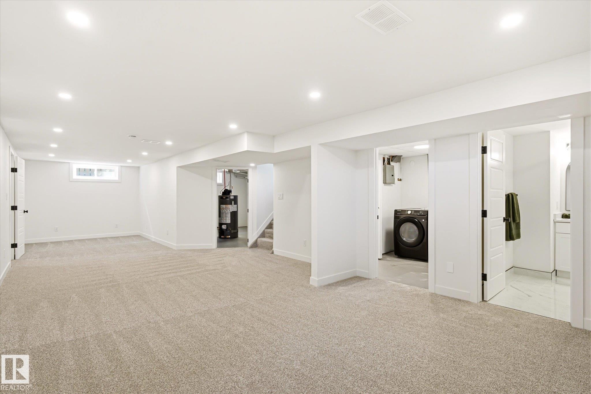 Spacious lower level featuring plush carpeting, recessed lighting, and a window for natural light - 4708 104A Avenue Nw, Edmonton, AB - Indoor
