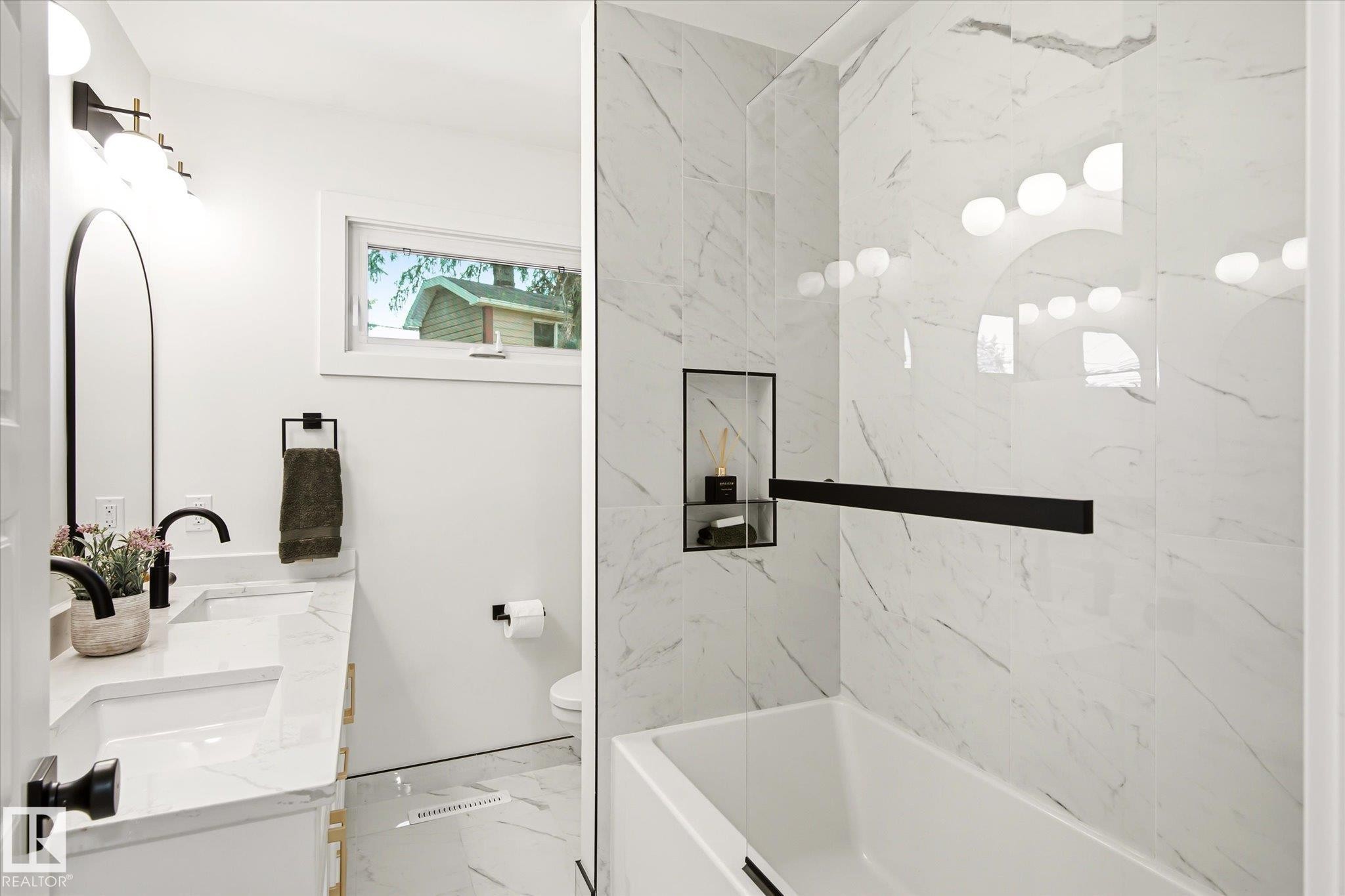 Modern bathroom featuring a dual vanity with undermount sinks, marble-patterned countertops, and matte black fixtures - 4708 104A Avenue Nw, Edmonton, AB - Indoor Photo Showing Bathroom