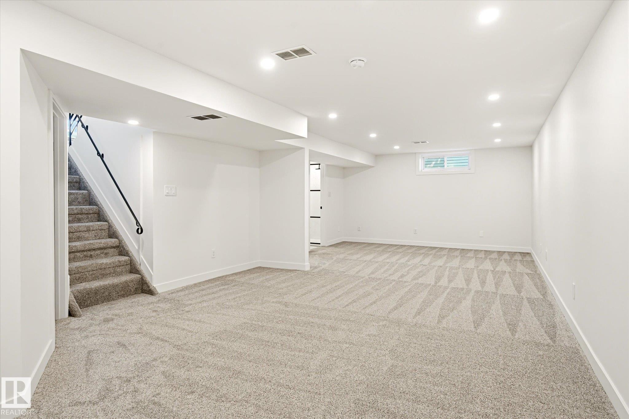 Spacious room featuring light-toned carpet flooring, white walls, and recessed lighting - 4708 104A Avenue Nw, Edmonton, AB - Indoor Photo Showing Other Room