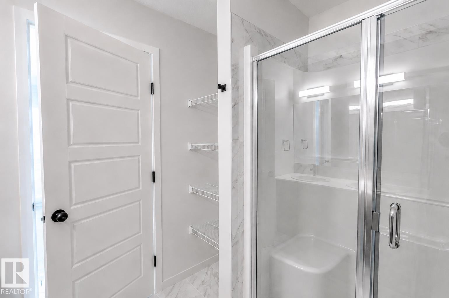 Walk-in shower with clear glass enclosure and integrated seating - 219 157 Avenue Ne, Edmonton, AB - Indoor Photo Showing Bathroom