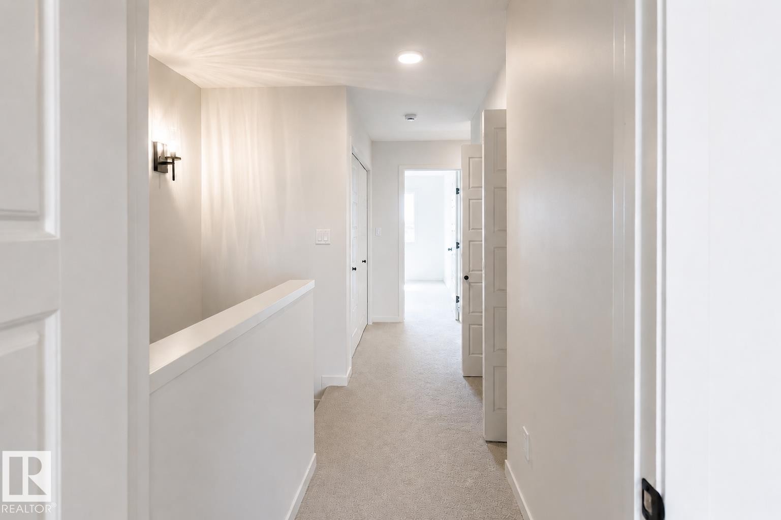 Hallway with neutral carpeting, recessed lighting, and a modern wall sconce - 219 157 Avenue Ne, Edmonton, AB - Indoor Photo Showing Other Room