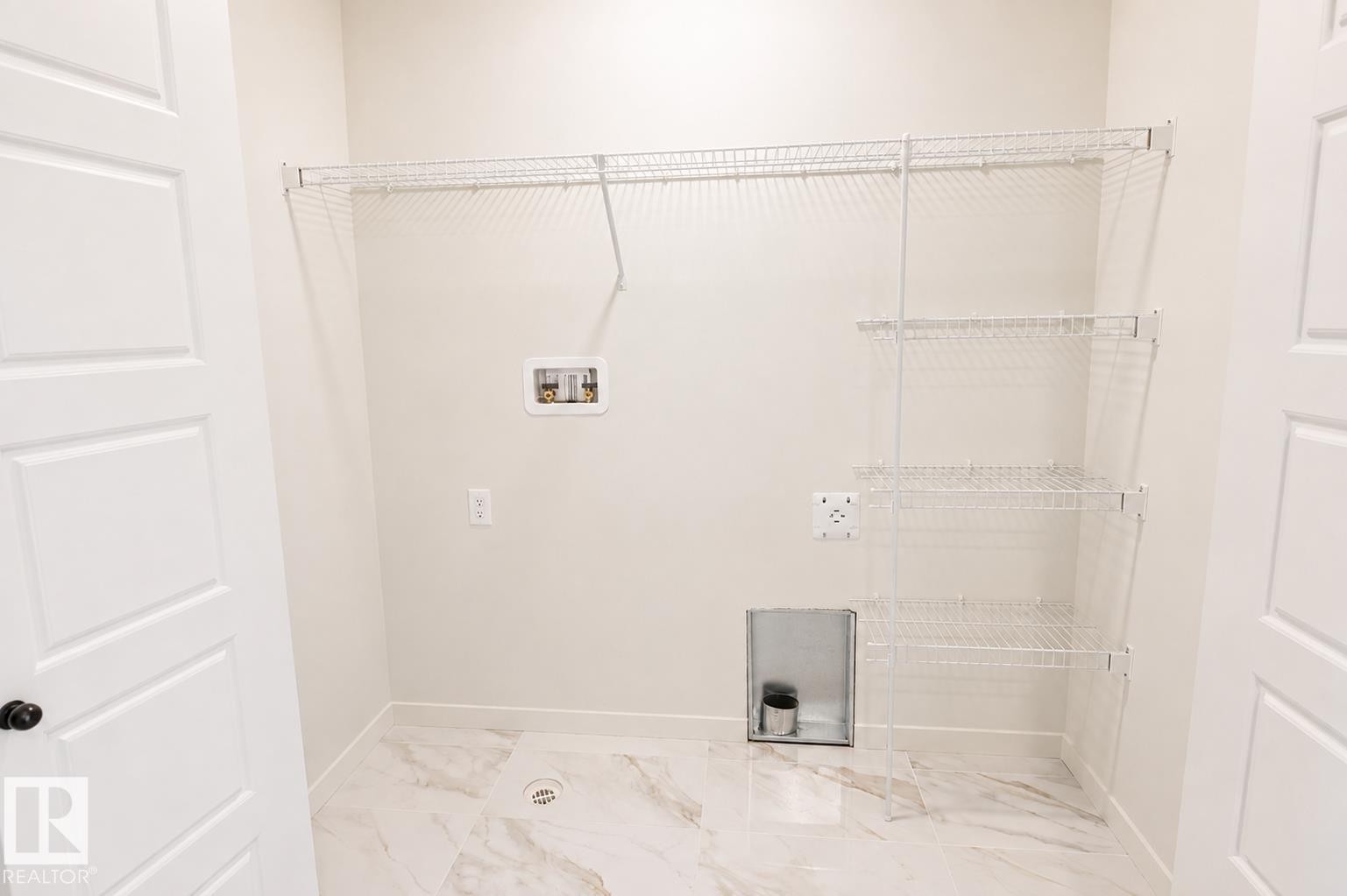 White wire shelving, white paneled door, light-toned walls, and marble-look floor tiling - 219 157 Avenue Ne, Edmonton, AB - Indoor With Storage