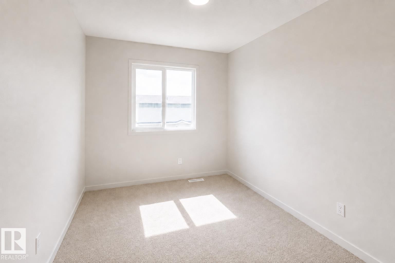 Neutral tone wall finish with carpeted flooring and an overhead flush-mount light fixture - 219 157 Avenue Ne, Edmonton, AB - Indoor Photo Showing Other Room
