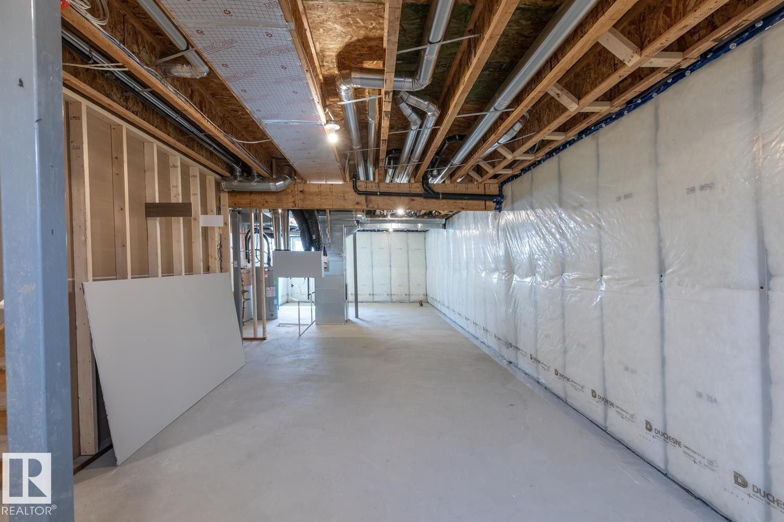 Unfinished basement featuring exposed wood joists, structural framing, concrete flooring, and insulated perimeter walls - 219 157 Avenue Ne, Edmonton, AB - Indoor Photo Showing Basement