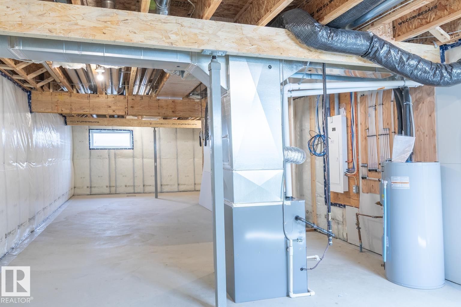 Unfinished basement featuring exposed wood joists, concrete flooring, a window, and utility systems - 219 157 Avenue Ne, Edmonton, AB - Indoor Photo Showing Basement