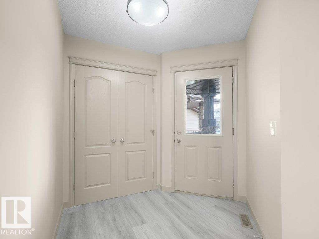 Wood-finish flooring, paneled doors, and a ceiling-mounted light fixture - 3010 17A Ave Nw, Edmonton, AB - Indoor Photo Showing Other Room