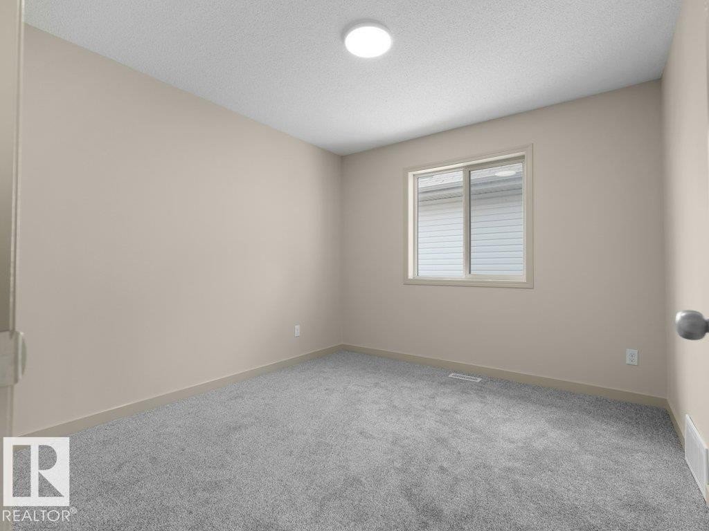 Neutral-toned walls, grey carpeting, and a flush-mount ceiling light fixture - 3010 17A Ave Nw, Edmonton, AB - Indoor Photo Showing Other Room