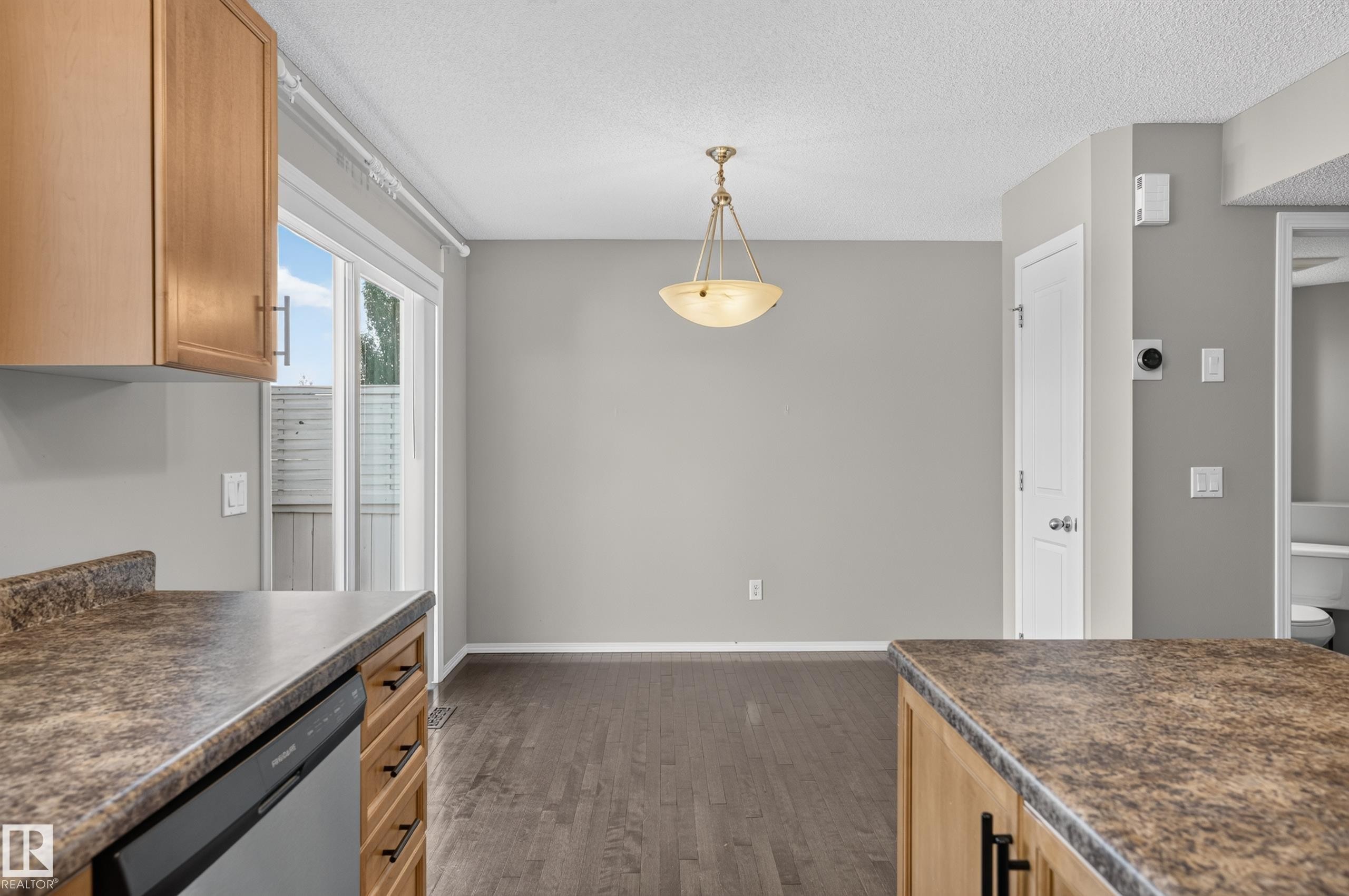 Wood-finish flooring throughout, with light wood cabinetry and dark countertops - 6008 South Terwillegar Boulevard Nw, Edmonton, AB - Indoor Photo Showing Kitchen