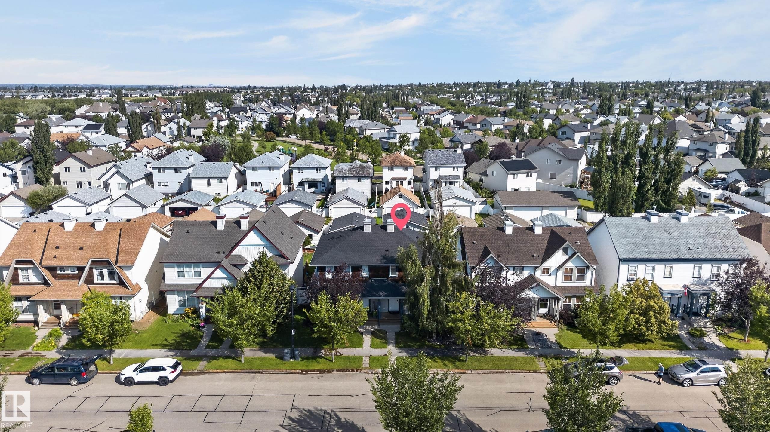 Residential property with a dark shingle roof, light-colored siding, and mature front landscaping - 6008 South Terwillegar Boulevard Nw, Edmonton, AB - Outdoor