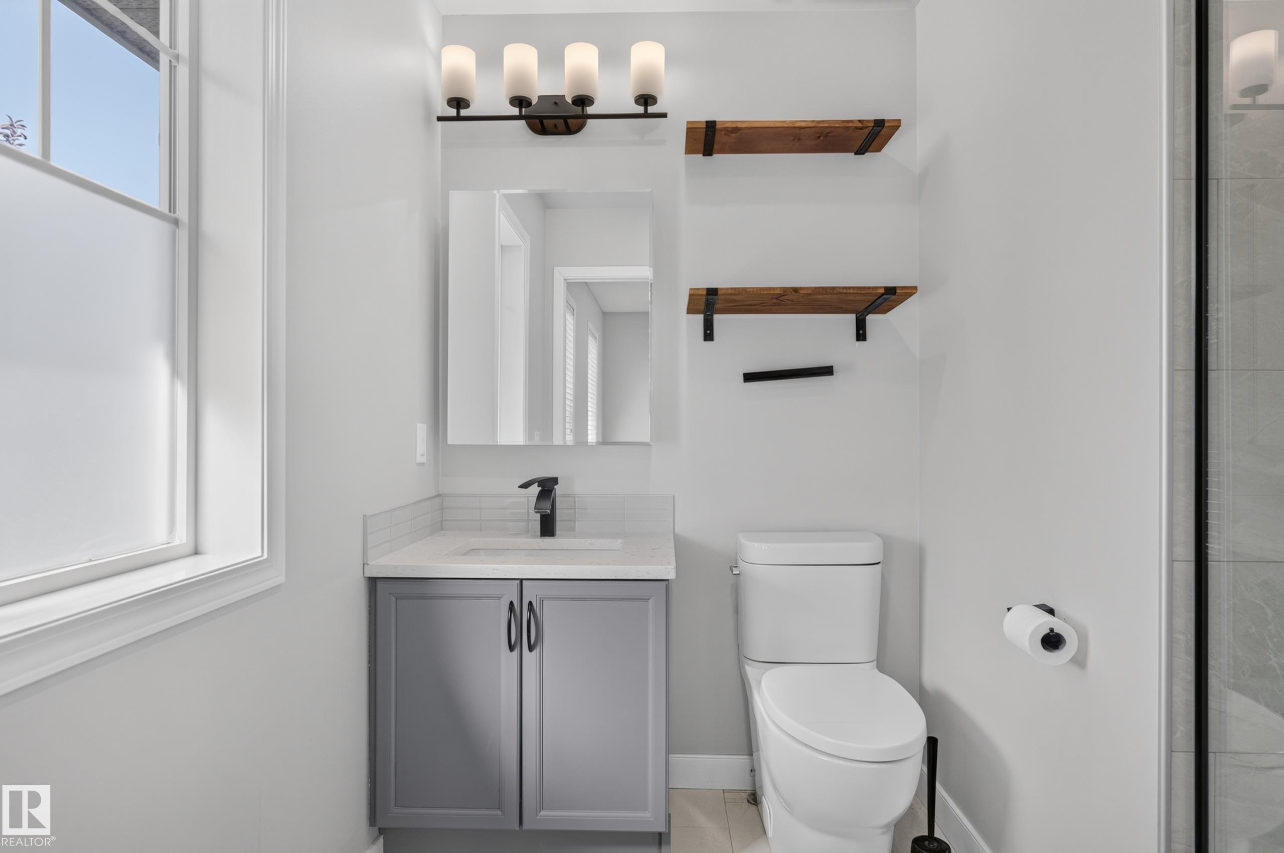 Frosted window, modern vanity with a single sink, black faucet, wall-mounted mirror, and decorative shelving - 6008 South Terwillegar Boulevard Nw, Edmonton, AB - Indoor Photo Showing Bathroom