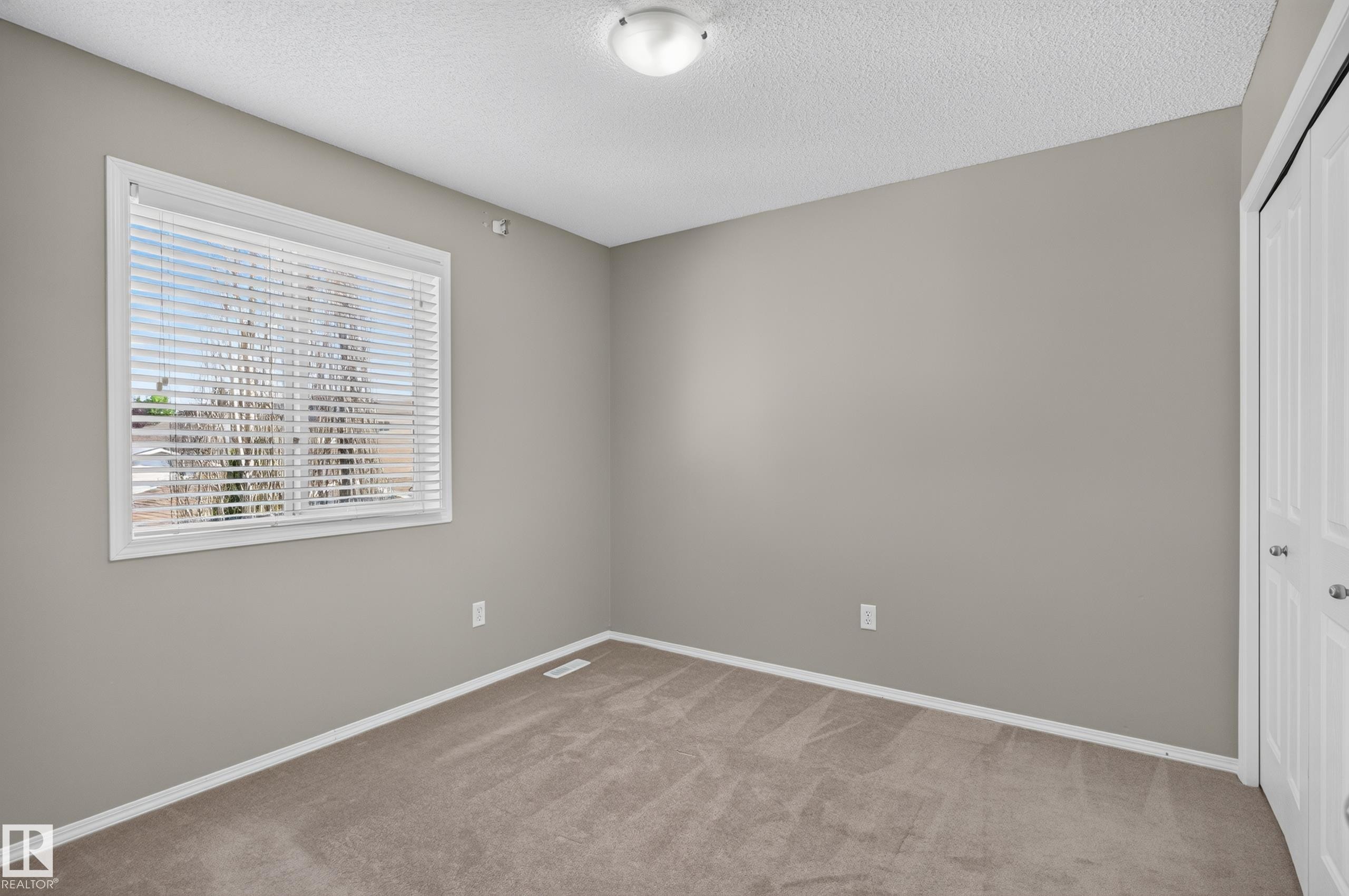 Wall-to-wall carpeting, window with blinds, bi-fold closet doors, and flush-mount ceiling light - 6008 South Terwillegar Boulevard Nw, Edmonton, AB - Indoor Photo Showing Other Room