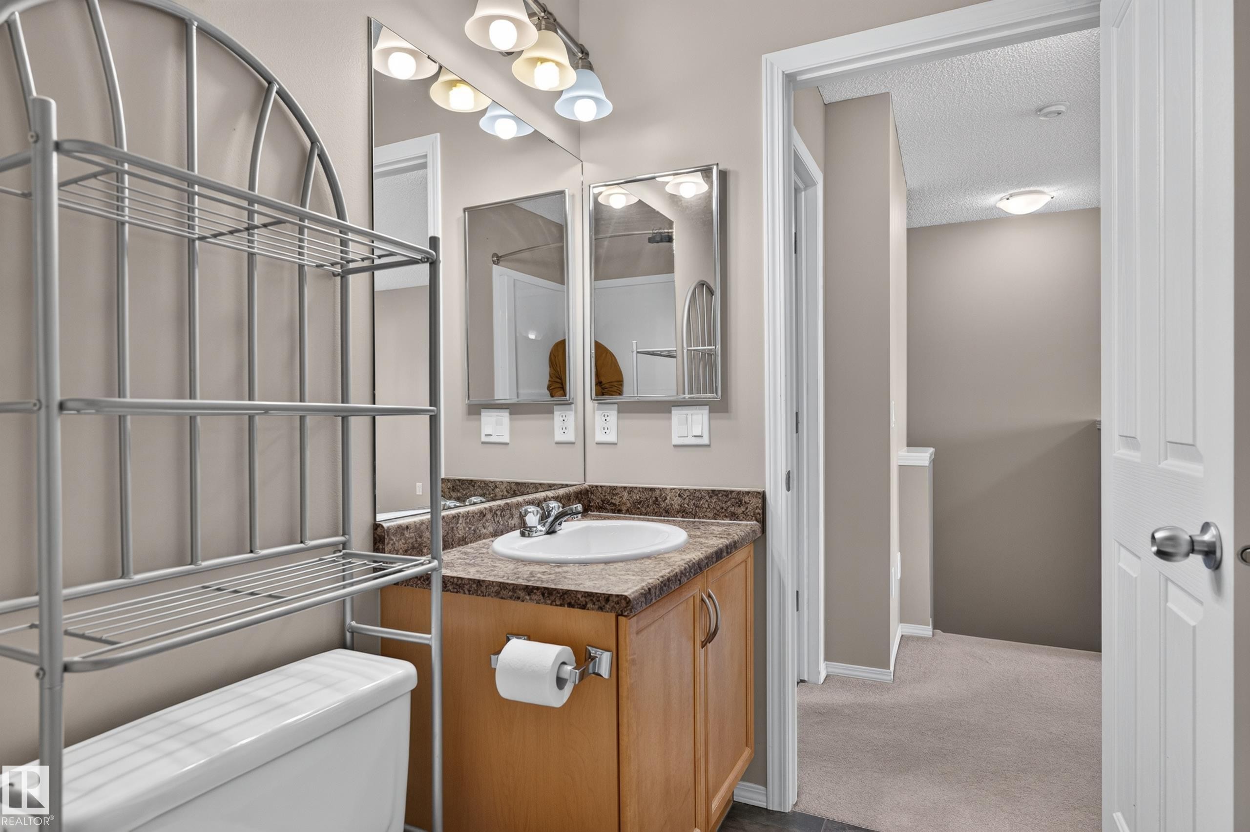 Vanity with a laminate countertop, integrated sink, and wood-finish cabinetry - 6008 South Terwillegar Boulevard Nw, Edmonton, AB - Indoor Photo Showing Bathroom