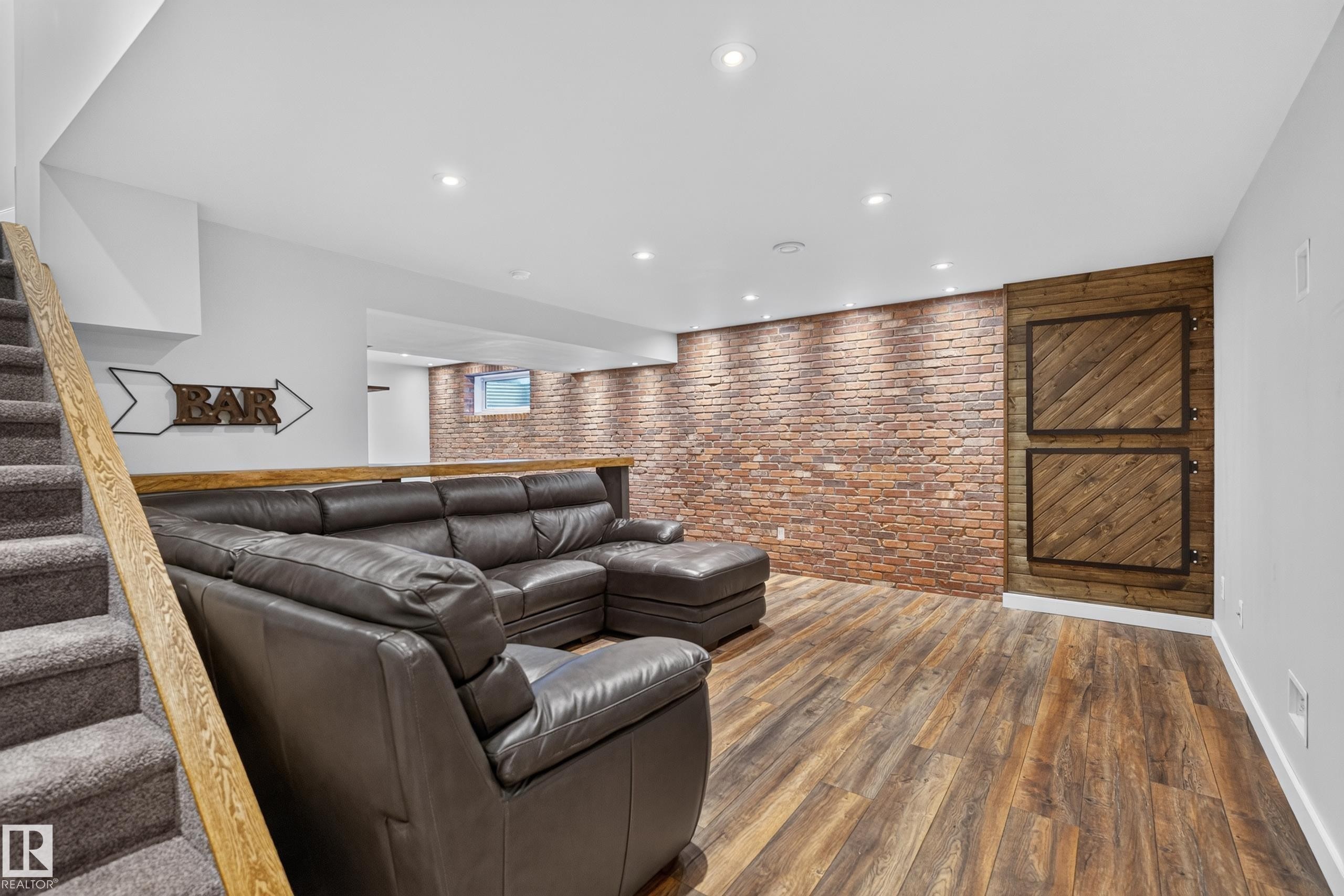Recessed lighting, wood-finish flooring, brick accent wall, wood-paneled wall feature, and a carpeted staircase with a wood handrail - 6008 South Terwillegar Boulevard Nw, Edmonton, AB - Indoor