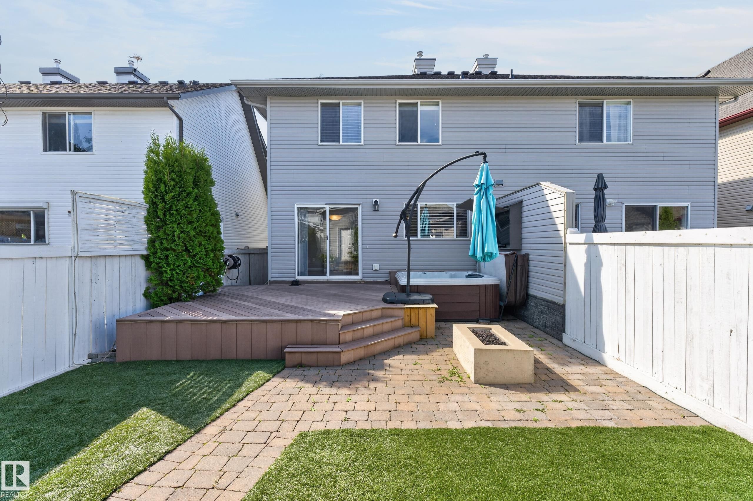 Expansive backyard featuring a wood-finish deck with stairs, a built-in hot tub, and a paver patio with a fire pit - 6008 South Terwillegar Boulevard Nw, Edmonton, AB - Outdoor With Deck Patio Veranda With Exterior