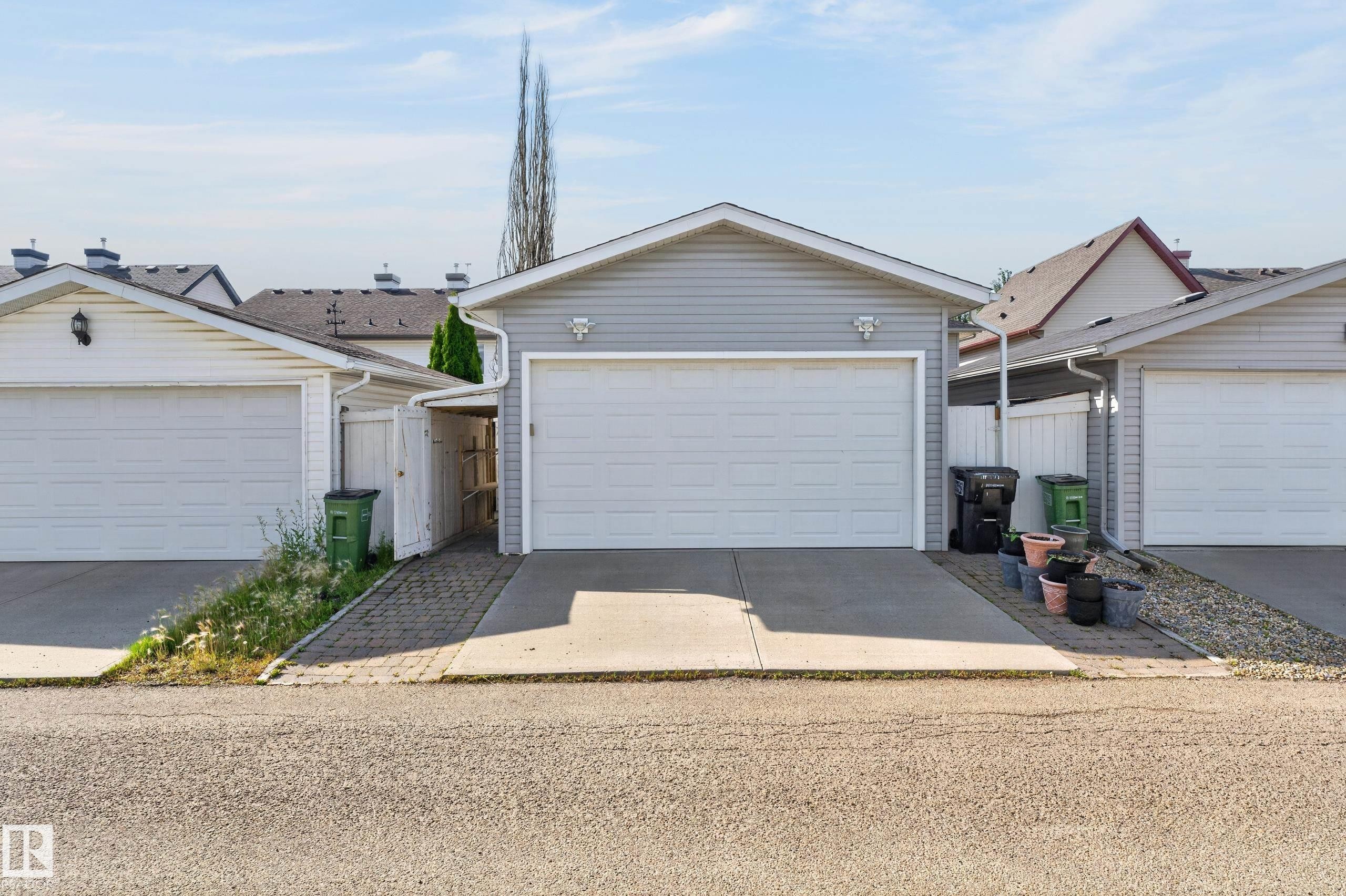 Attached garage with light grey siding, white garage door, and a concrete driveway - 6008 South Terwillegar Boulevard Nw, Edmonton, AB - Outdoor