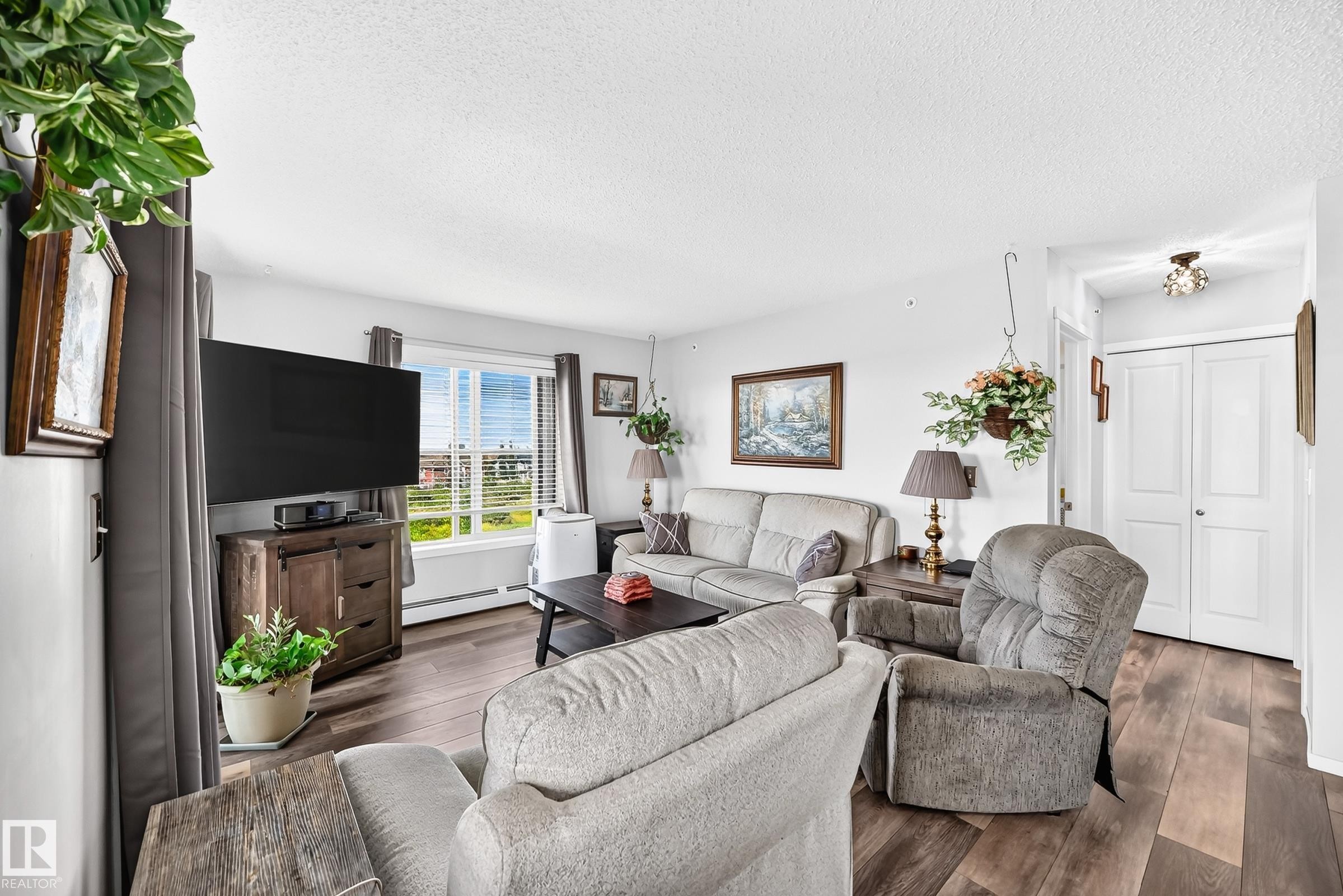 Hardwood-style flooring, white walls, and a window with horizontal blinds - #401 5390 Chappelle Rd Sw, Edmonton, AB
