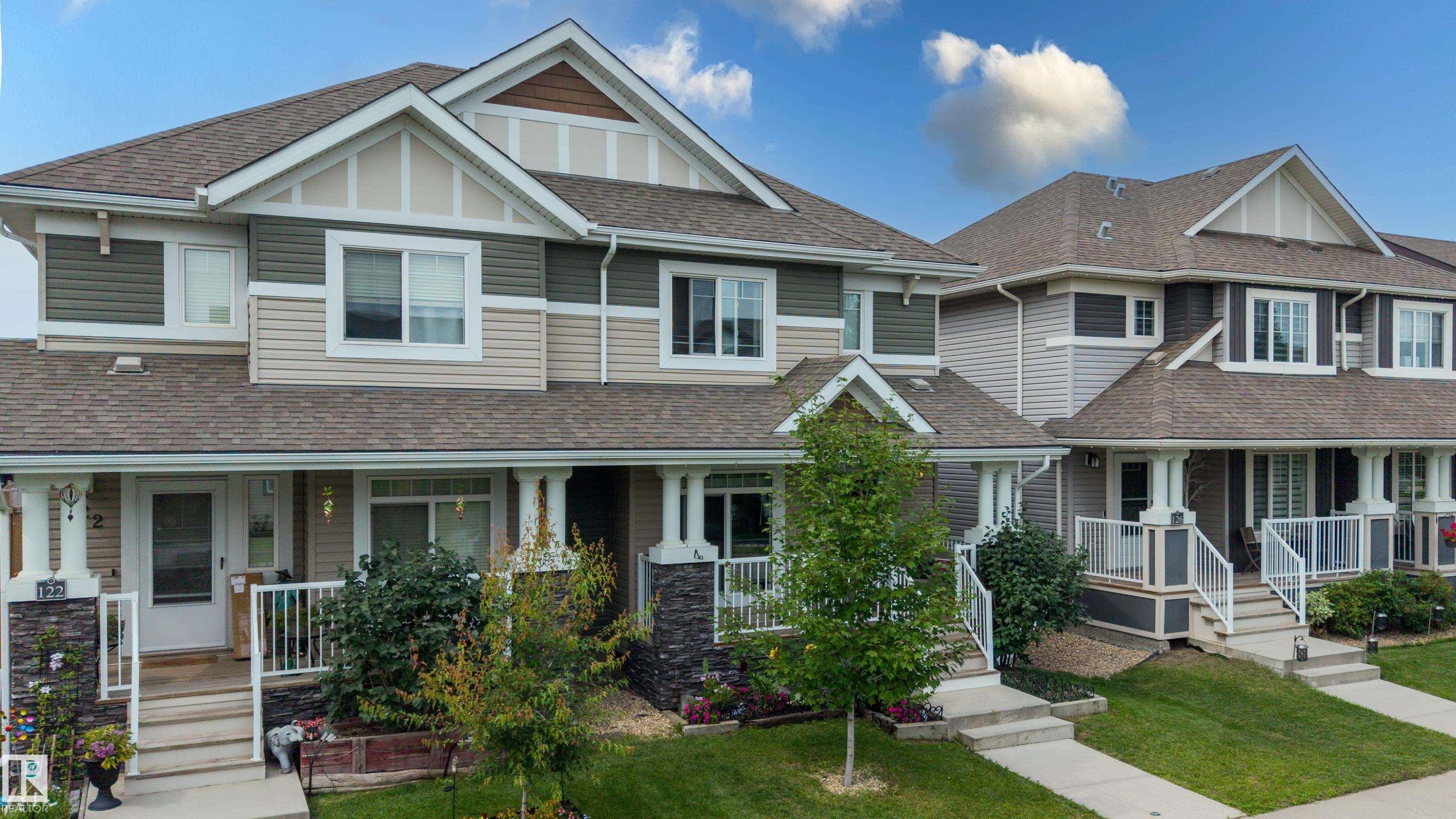 Multi-level facade featuring varied siding materials, gabled rooflines, and individual covered front porches with white railings - 124 Cy Becker Boulevard Nw, Edmonton, AB - Outdoor With View