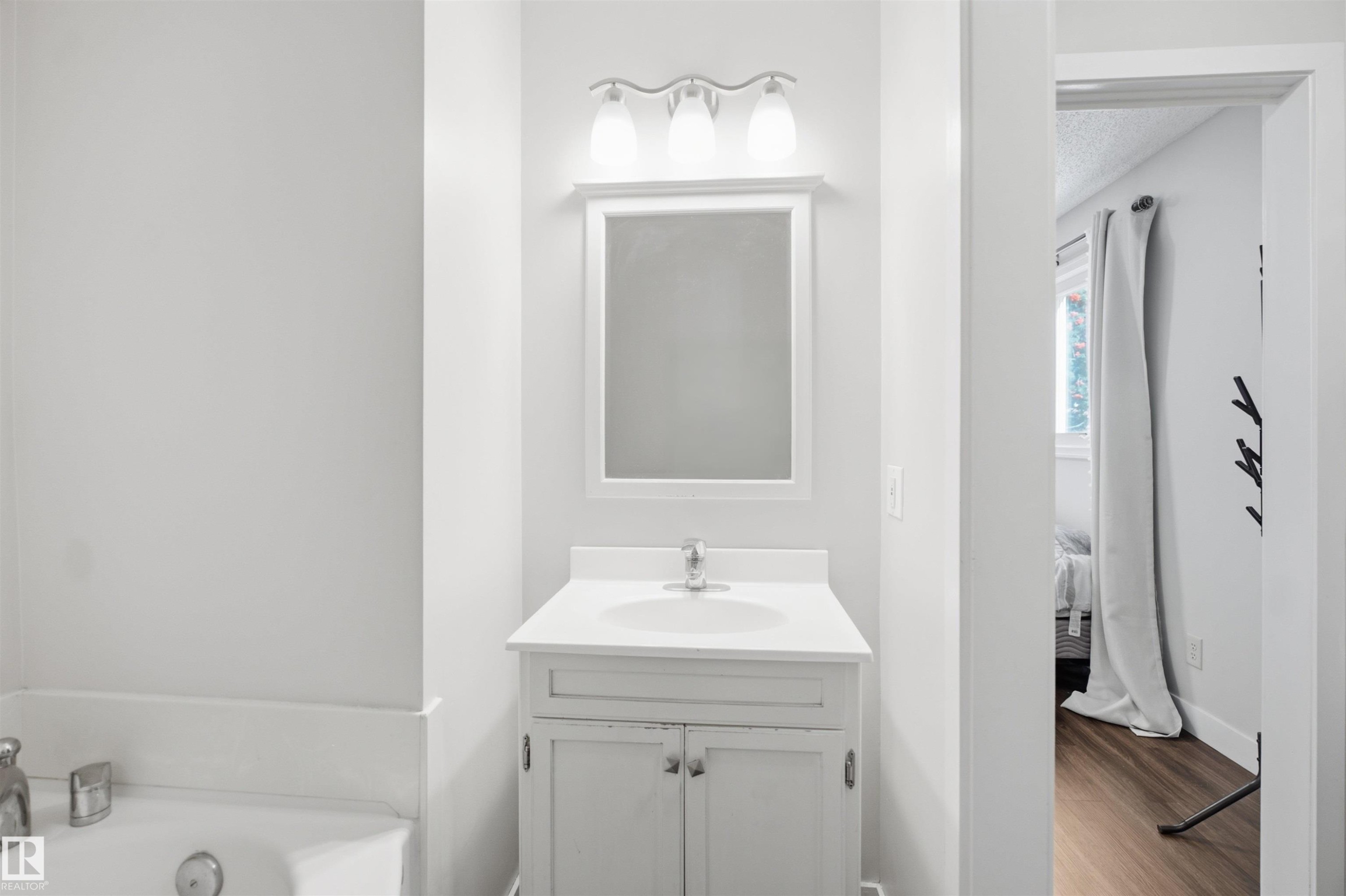 Vanity with an integrated sink, polished chrome faucet, and white countertop - 3515 20 Ave Nw, Edmonton, AB