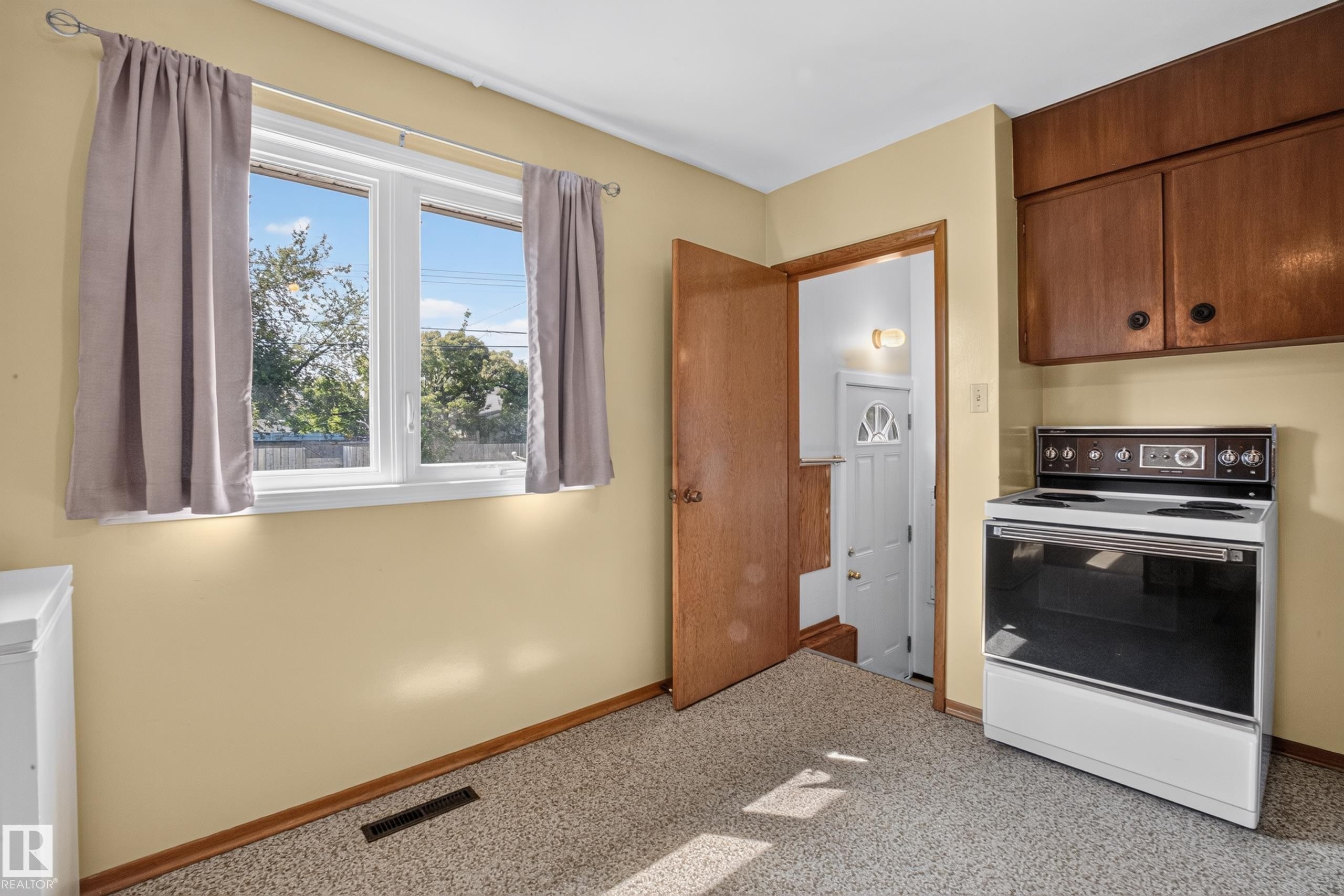 White-framed window, wall-mounted cabinetry, built-in range, and carpet flooring - 16009 93A Avenue Nw, Edmonton, AB - Indoor