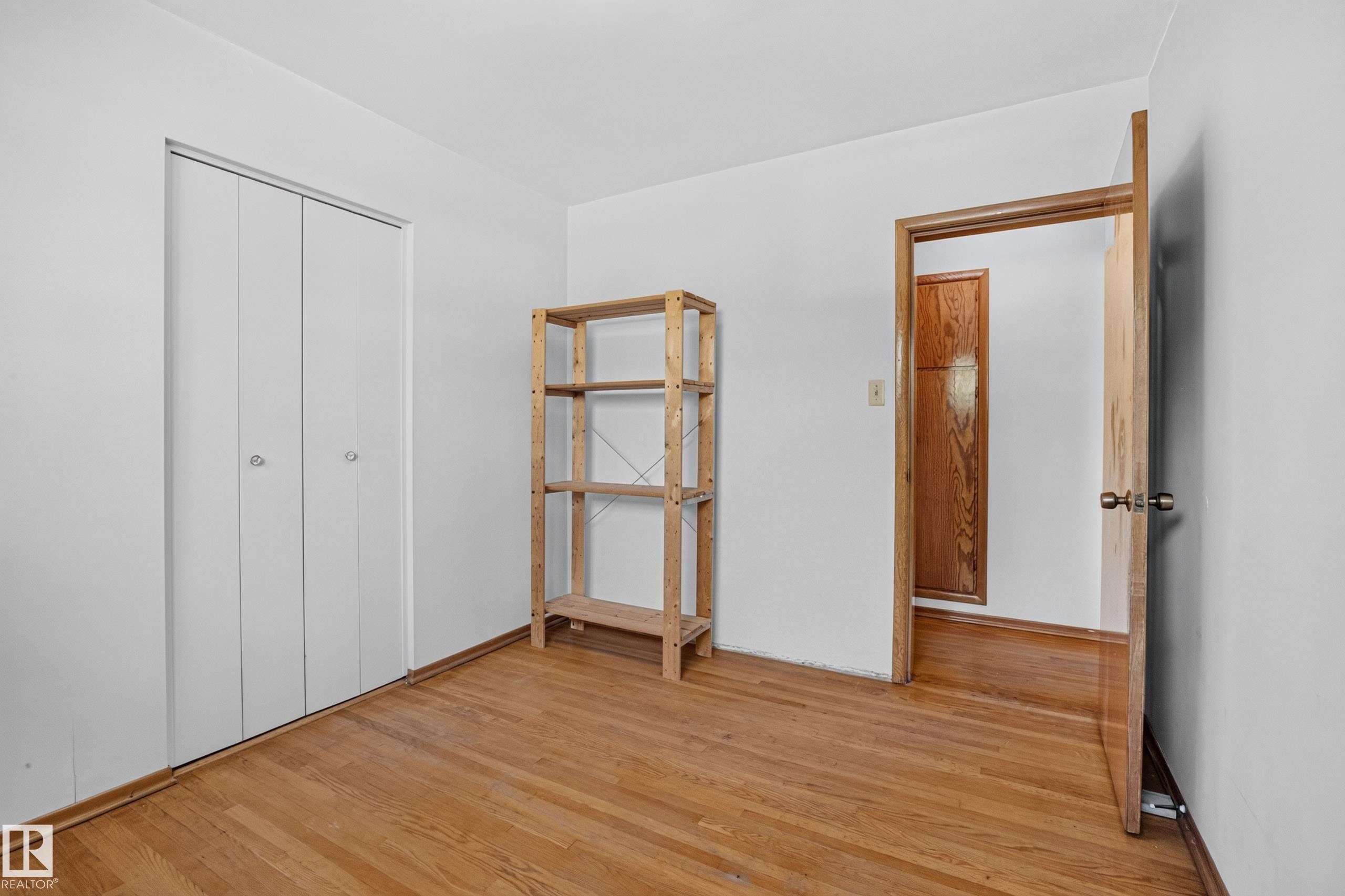 Hardwood flooring, white walls, and a wood-finish door frame - 16009 93A Avenue Nw, Edmonton, AB - Indoor