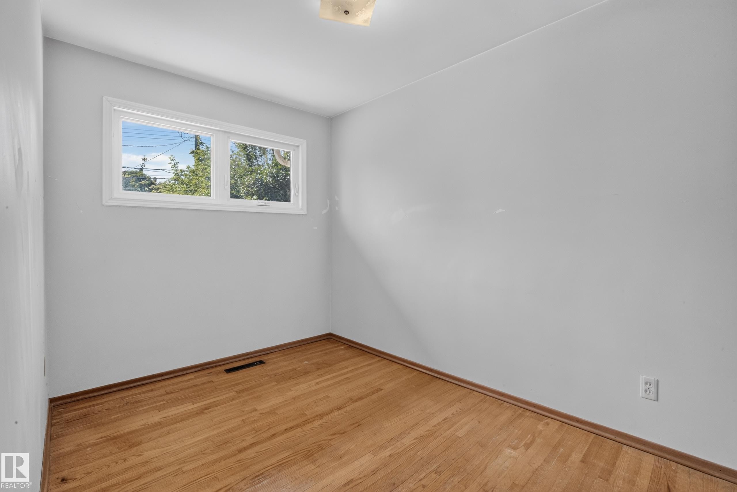 Hardwood flooring, white walls, and a window providing natural illumination - 16009 93A Avenue Nw, Edmonton, AB - Indoor Photo Showing Other Room