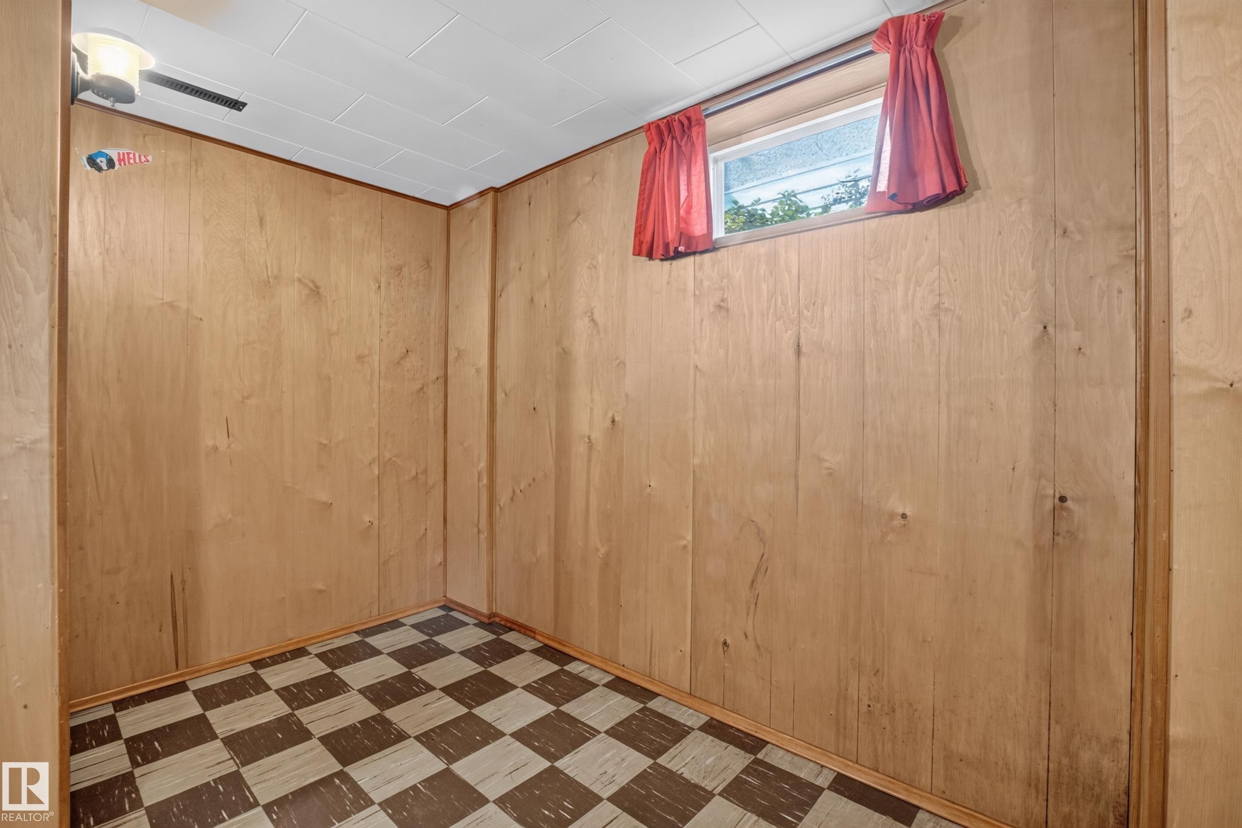 Wood-paneled room featuring a window and checkered flooring - 16009 93A Avenue Nw, Edmonton, AB - Indoor Photo Showing Other Room