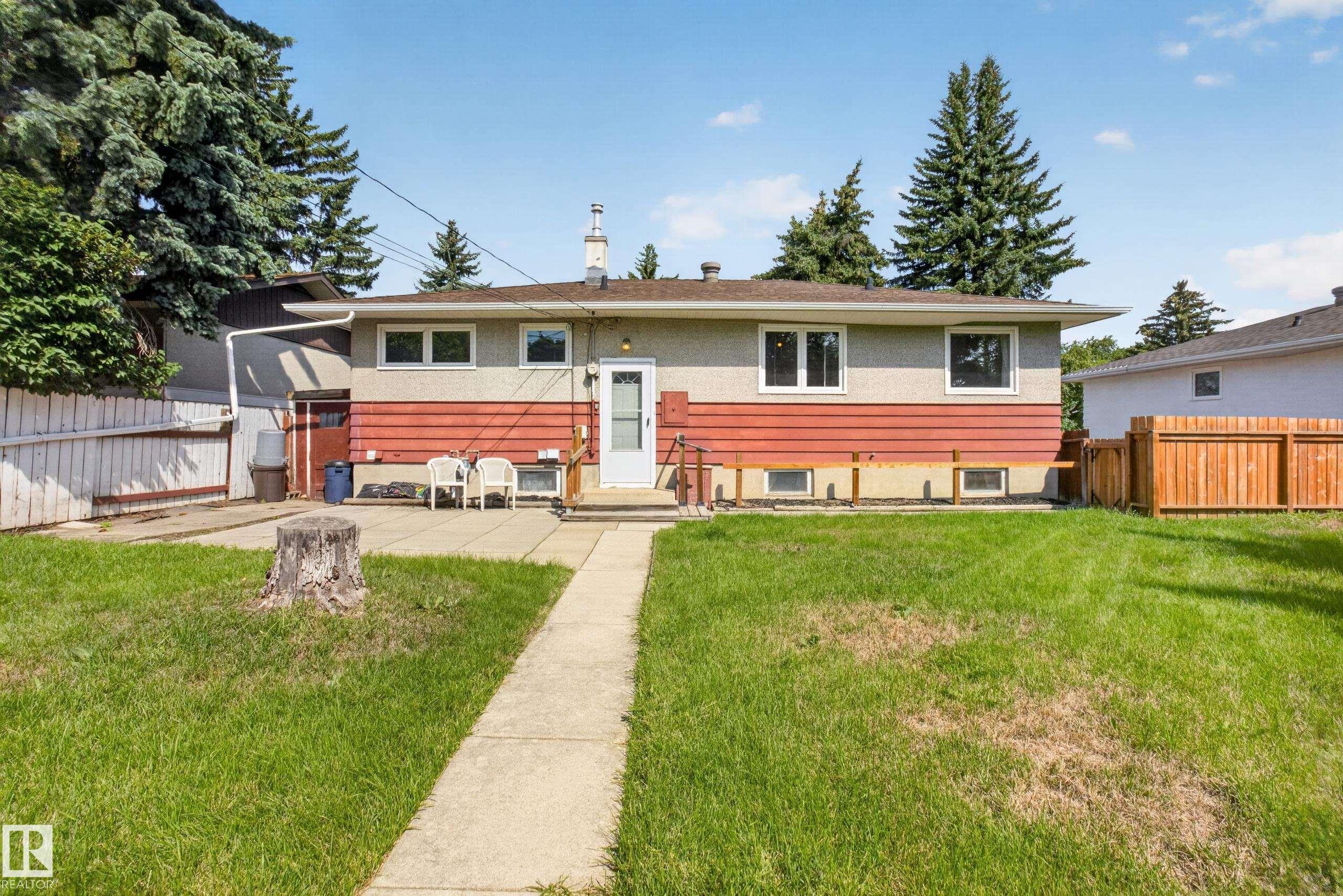 Expansive backyard featuring a concrete pathway, patio area, and mature trees - 16009 93A Avenue Nw, Edmonton, AB - Outdoor