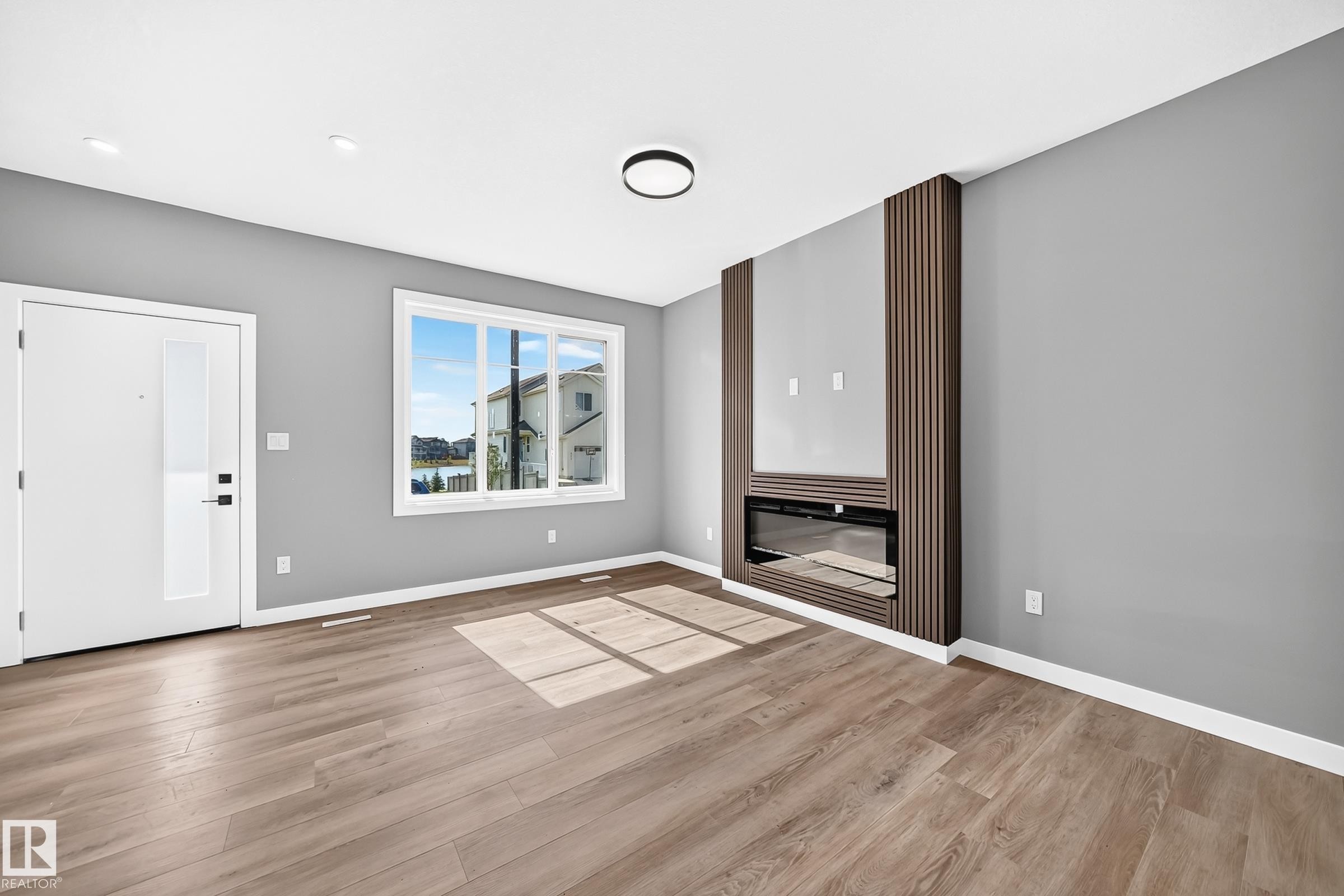 Wood-finish flooring, recessed lighting, and a modern ceiling fixture - 426 Crystal Creek Link, Leduc, AB - Indoor Photo Showing Other Room