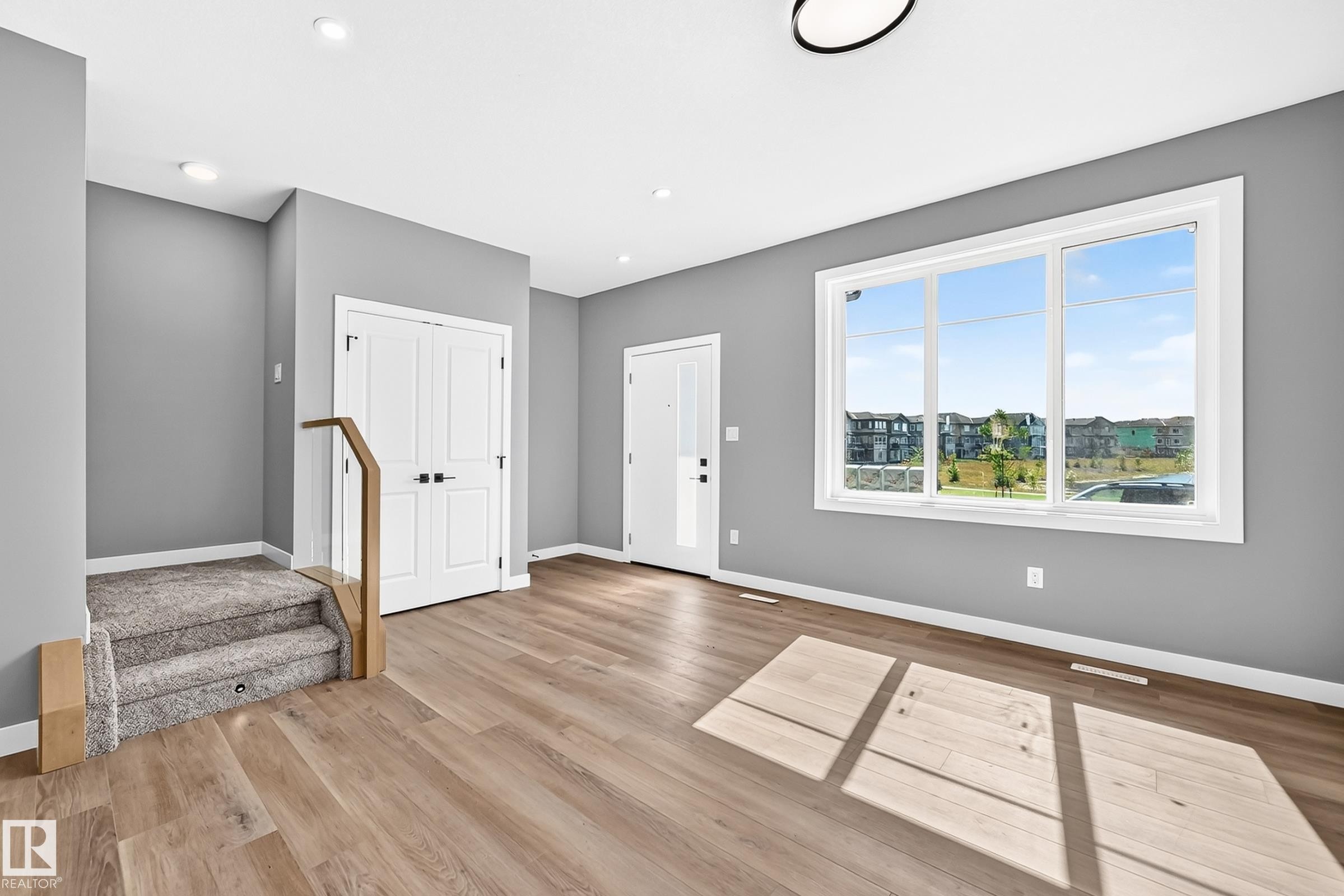 Wood-finish flooring, recessed lighting, and a large multi-pane window - 426 Crystal Creek Link, Leduc, AB - Indoor Photo Showing Other Room