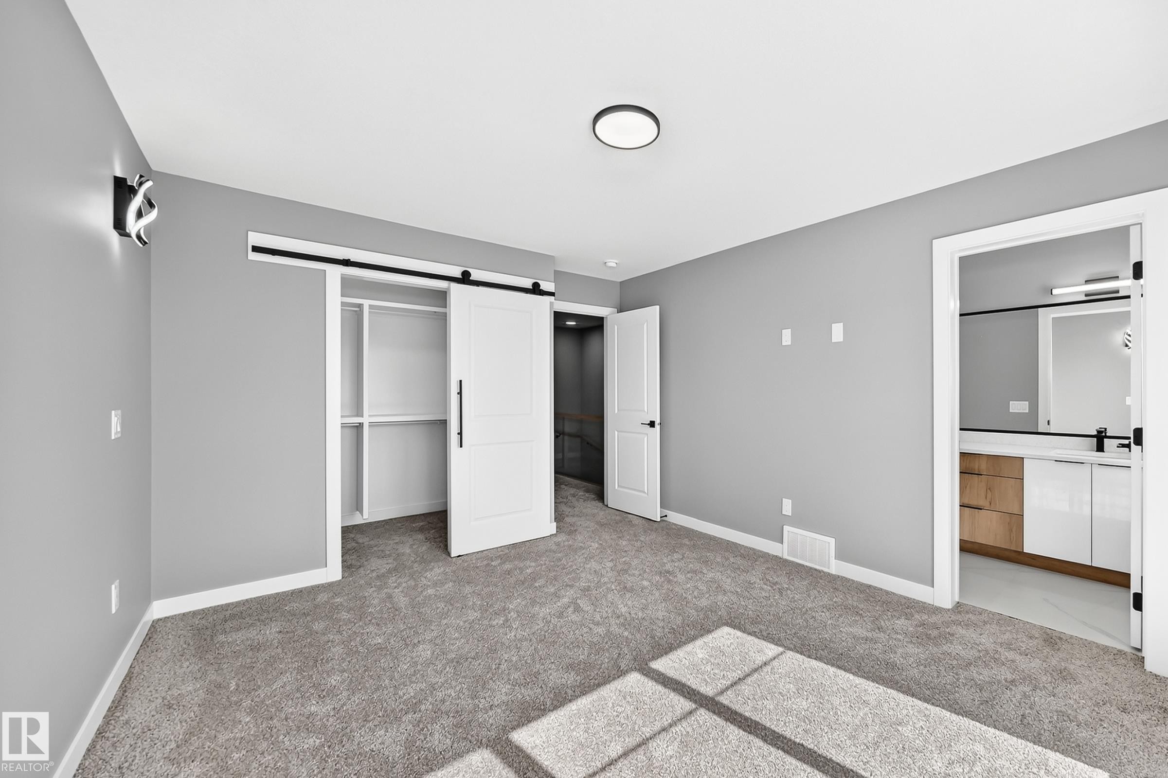 Gray carpeting, white walls, and a modern ceiling light fixture - 426 Crystal Creek Link, Leduc, AB - Indoor Photo Showing Other Room
