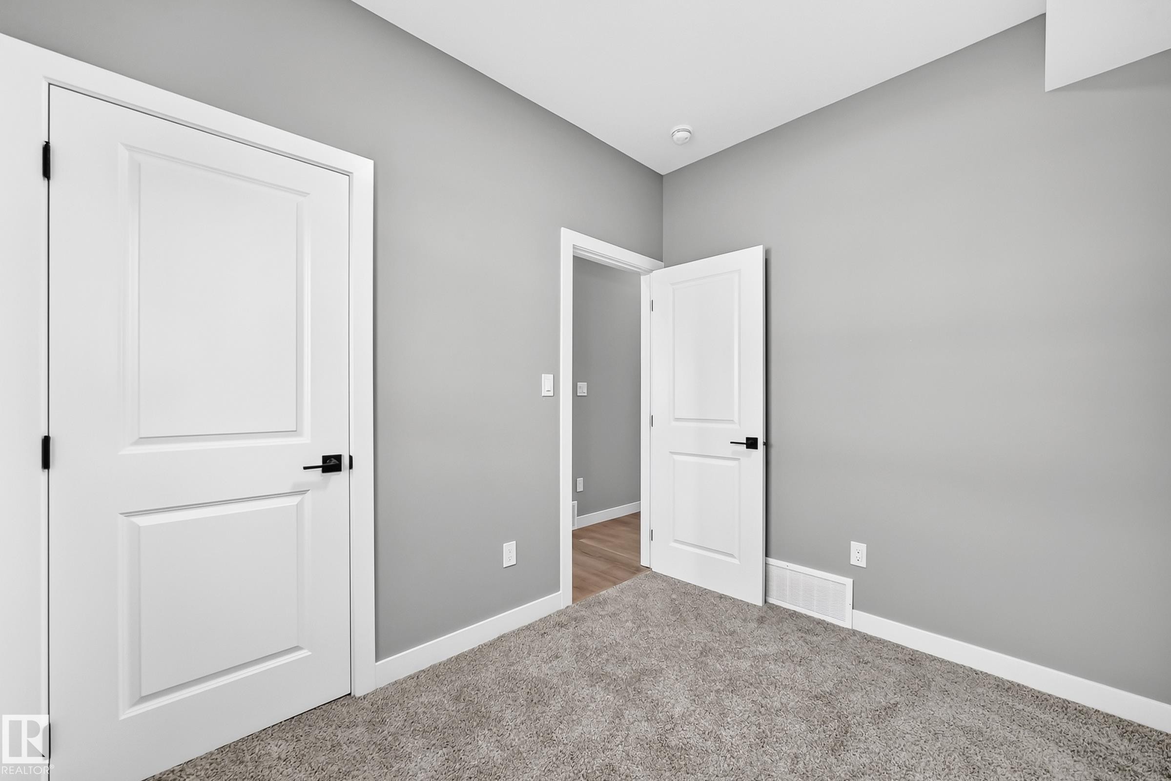 Neutral wall color, carpeted flooring, white trim, recessed lighting, and panel doors with matte black hardware - 426 Crystal Creek Link, Leduc, AB - Indoor Photo Showing Other Room