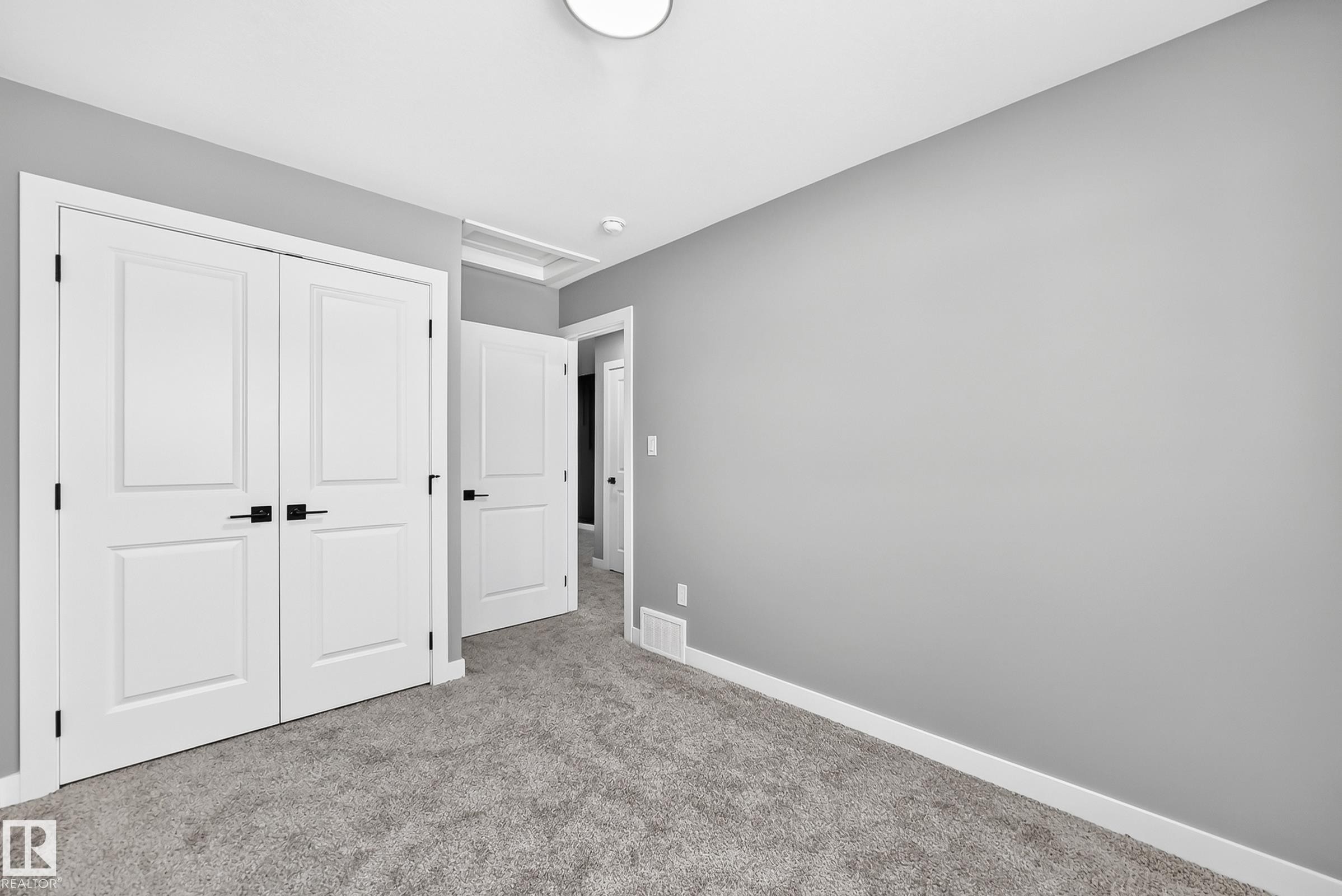 Textured gray carpeting with white baseboards - 426 Crystal Creek Link, Leduc, AB - Indoor Photo Showing Other Room