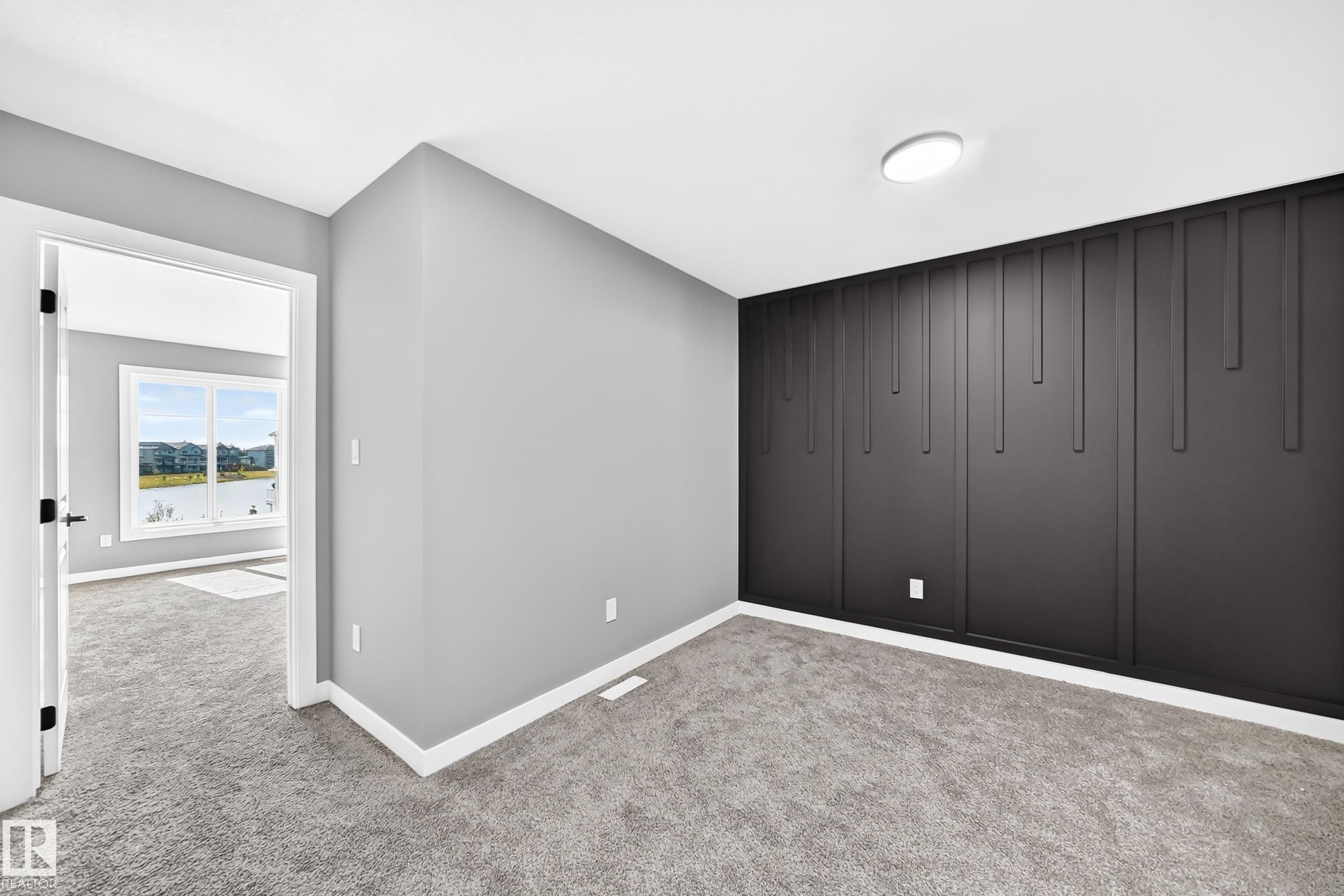 Textured accent wall, neutral carpeting, recessed lighting, and a white trim finish - 426 Crystal Creek Link, Leduc, AB - Indoor Photo Showing Other Room