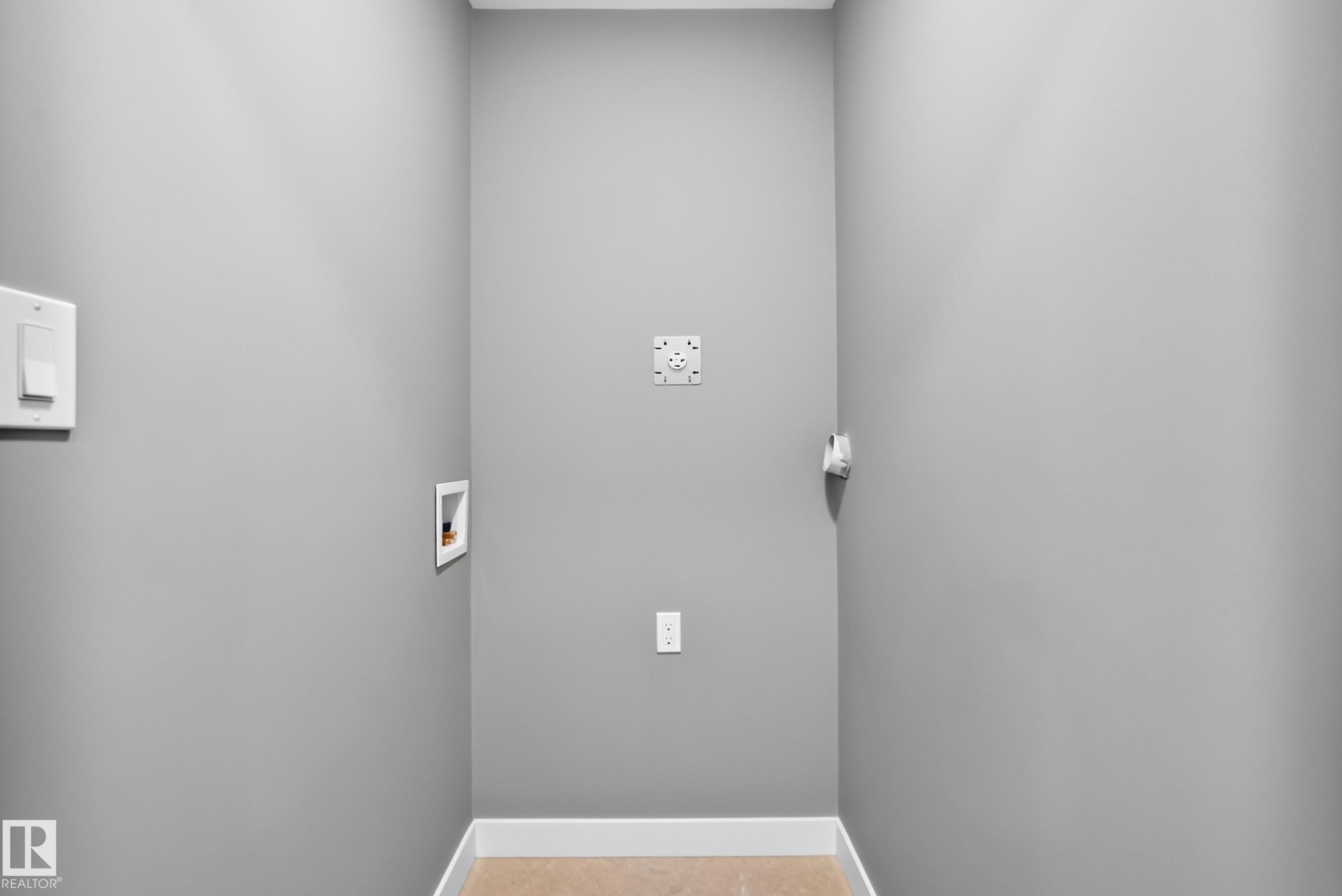 Light gray walls with white trim and light-toned flooring, featuring a wall-mounted light switch and power outlets - 426 Crystal Creek Link, Leduc, AB - Indoor Photo Showing Other Room