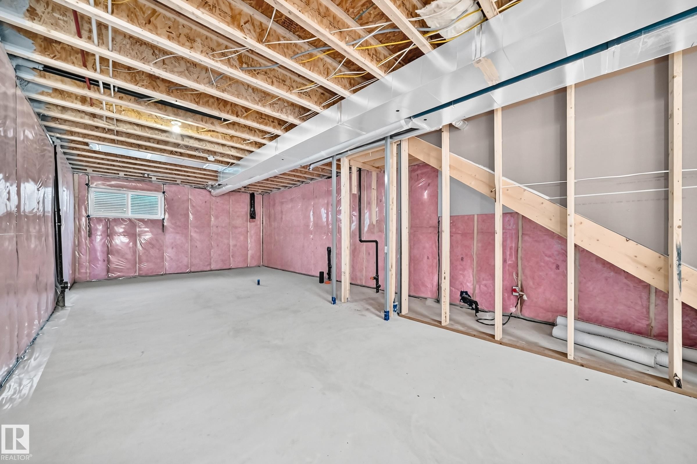 Unfinished basement with exposed ceiling joists, concrete flooring, wall insulation, a window opening, and framed walls - 426 Crystal Creek Link, Leduc, AB - Indoor Photo Showing Basement