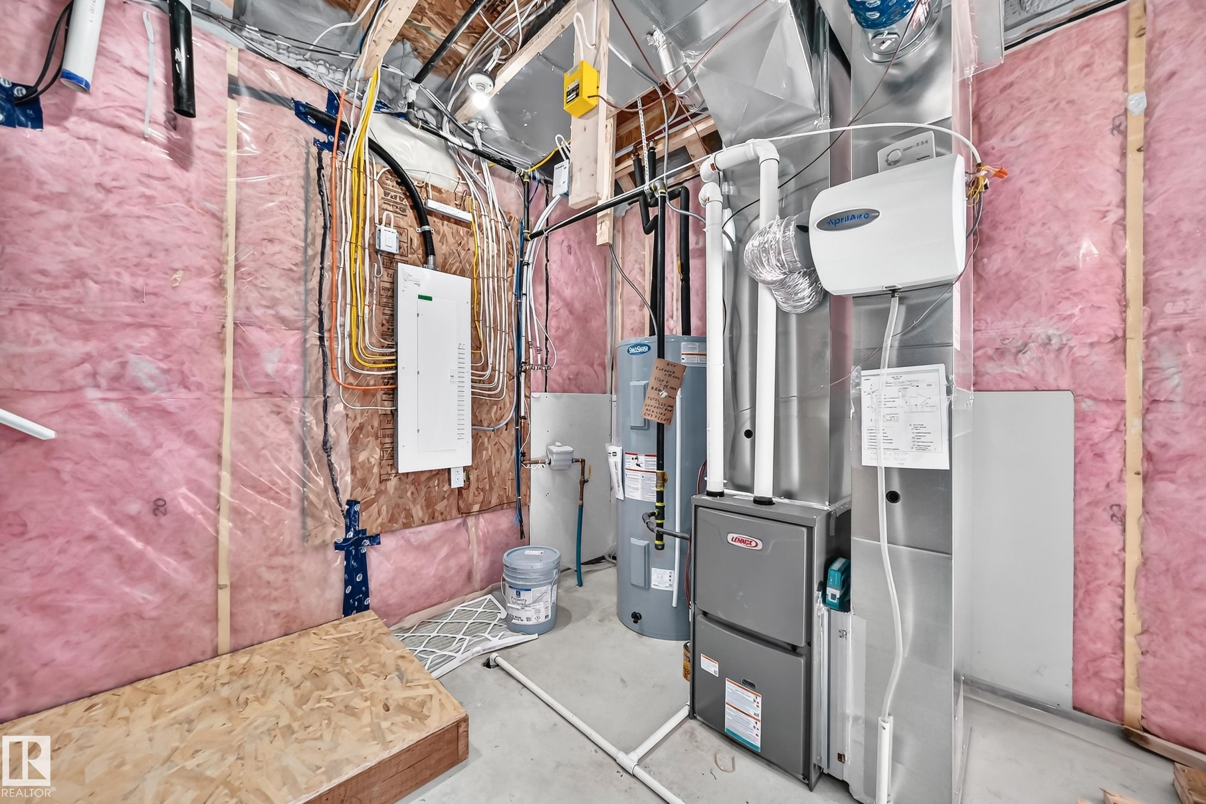 Insulated walls with visible framing, modern electrical panel, furnace system, water heater, and overhead ductwork - 426 Crystal Creek Link, Leduc, AB - Indoor Photo Showing Basement