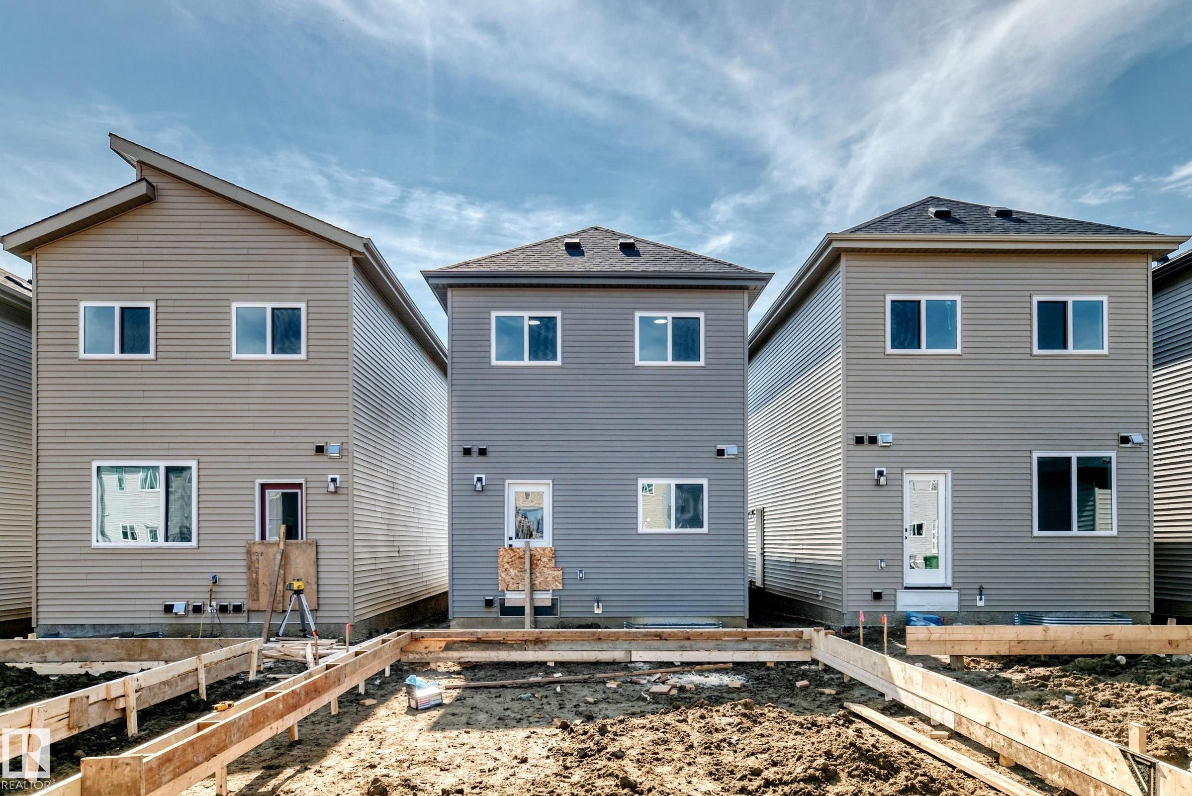 New construction home with contemporary siding, multiple windows, and a rear entry door - 426 Crystal Creek Link, Leduc, AB - Outdoor With Exterior