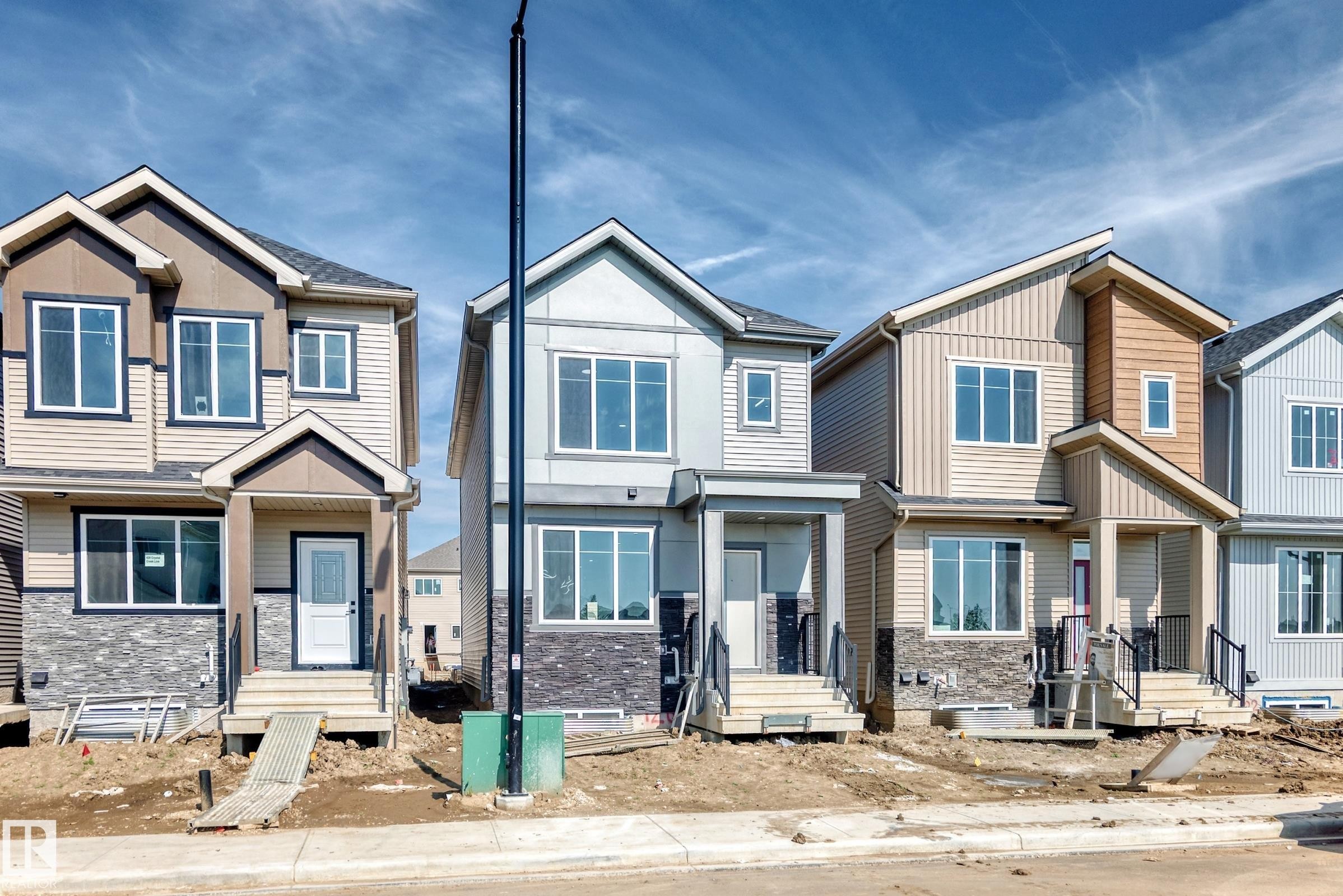 Exterior featuring multi-tone siding, stone accents, and multiple windows - 426 Crystal Creek Link, Leduc, AB - Outdoor With Facade