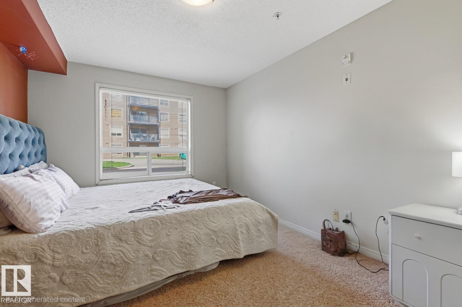 Hardwood-finish flooring, white walls, and a large window with white trim - #106 13907 136 St Nw, Edmonton, AB - Indoor Photo Showing Bedroom