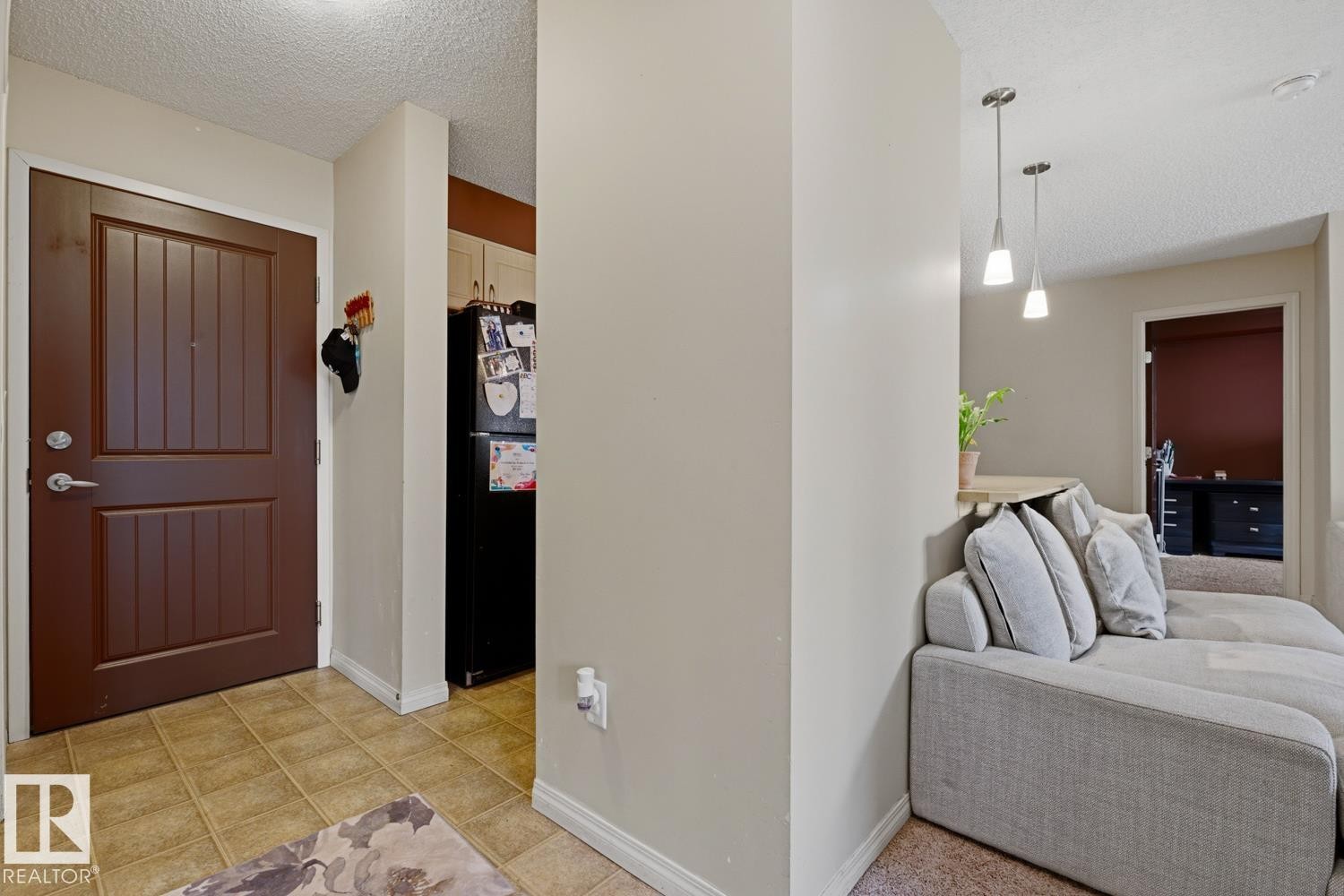 Paneled entry door, tiled flooring, pendant lighting, and light-toned walls - #106 13907 136 St Nw, Edmonton, AB - Indoor