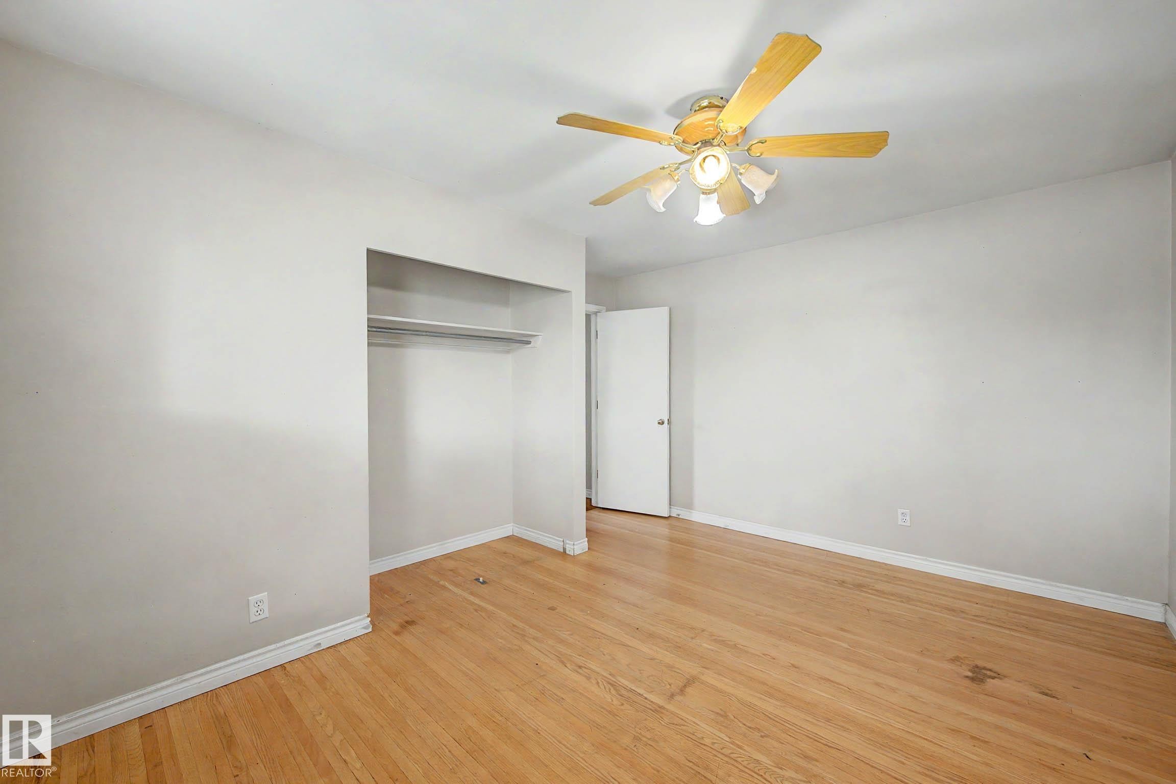 Wood-finish flooring with white walls - 9723 76 Street Nw, Edmonton, AB - Indoor Photo Showing Other Room