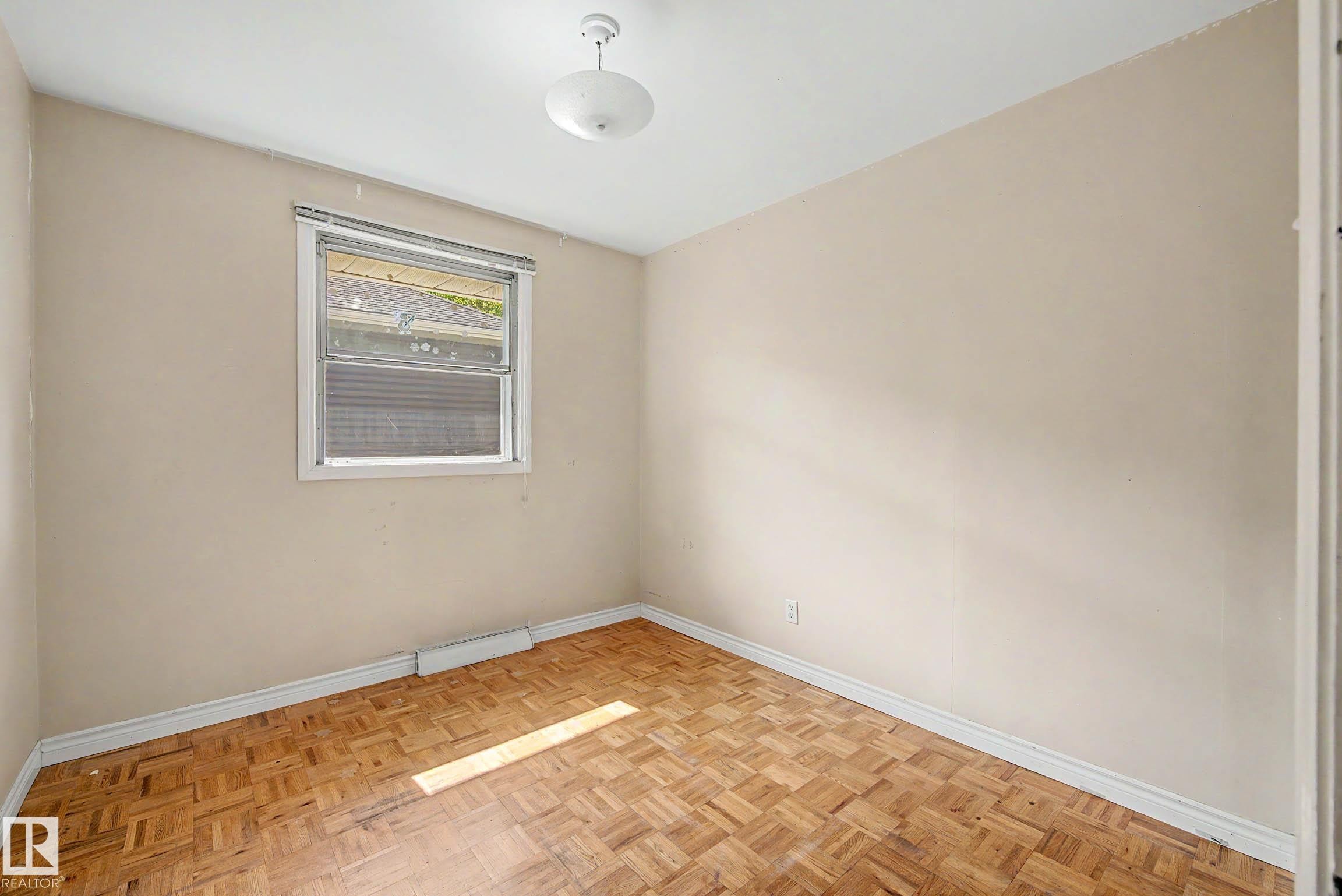 Parquet wood flooring, a single window, and a flush mount ceiling light - 9723 76 Street Nw, Edmonton, AB - Indoor Photo Showing Other Room