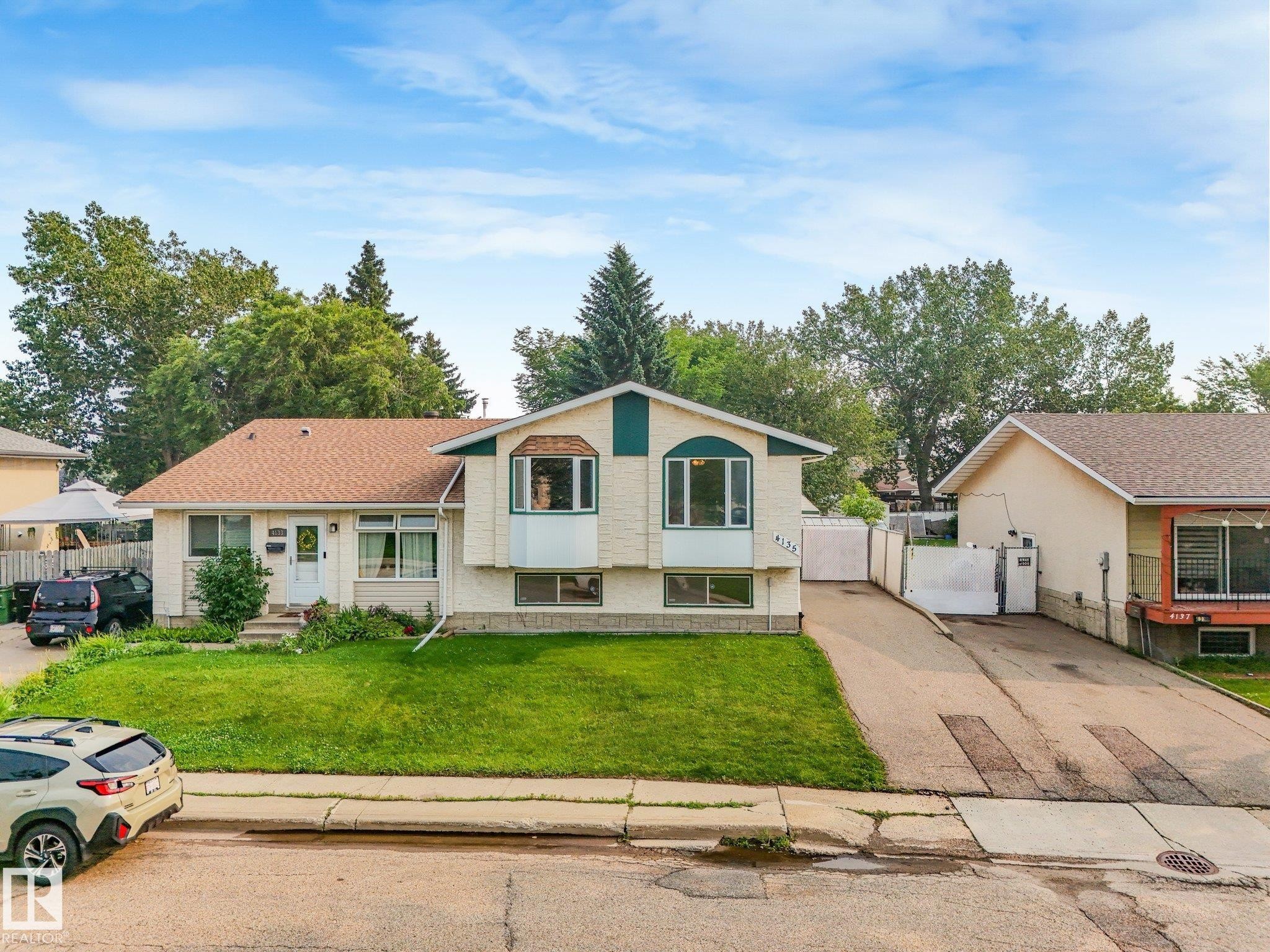 Cream-colored exterior with a contrasting green accent - 4135 134 Avenue Nw, Edmonton, AB - Outdoor With Facade