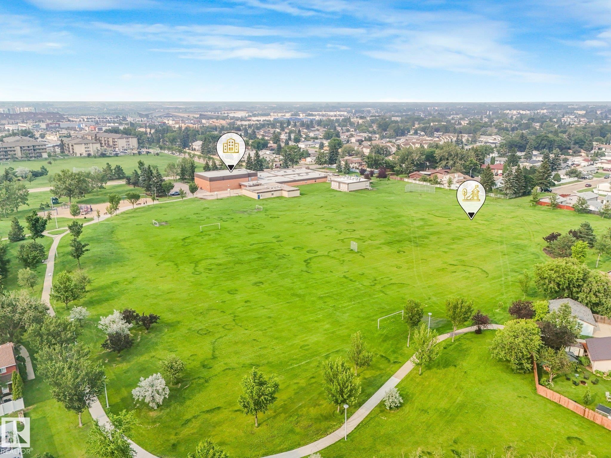 Expansive green space featuring curved paved paths, mature trees, and sports fields - 4135 134 Avenue Nw, Edmonton, AB - Outdoor With View