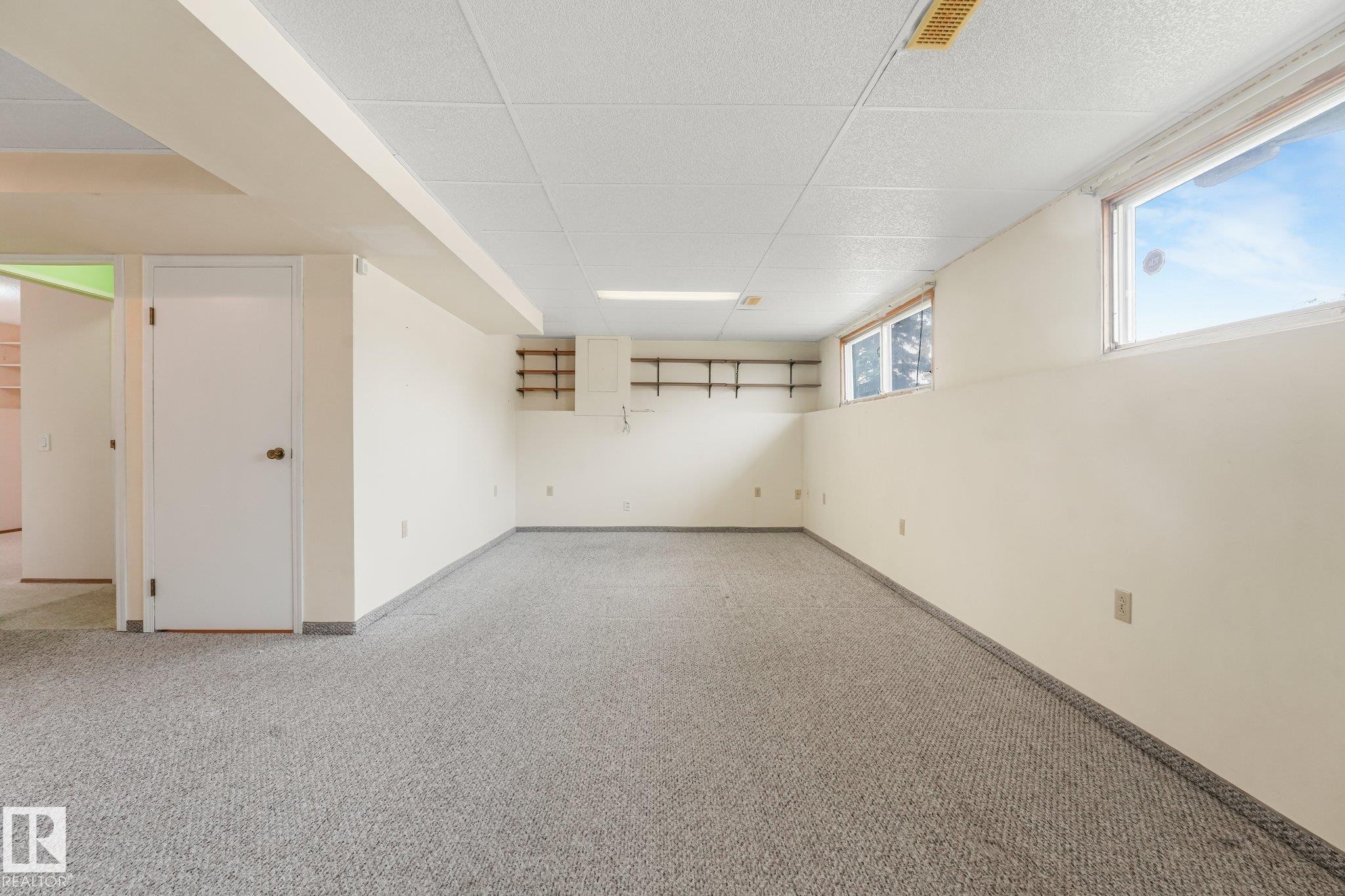 Spacious room featuring light-colored carpet, white walls, and a drop ceiling - 4135 134 Avenue Nw, Edmonton, AB - Indoor Photo Showing Other Room