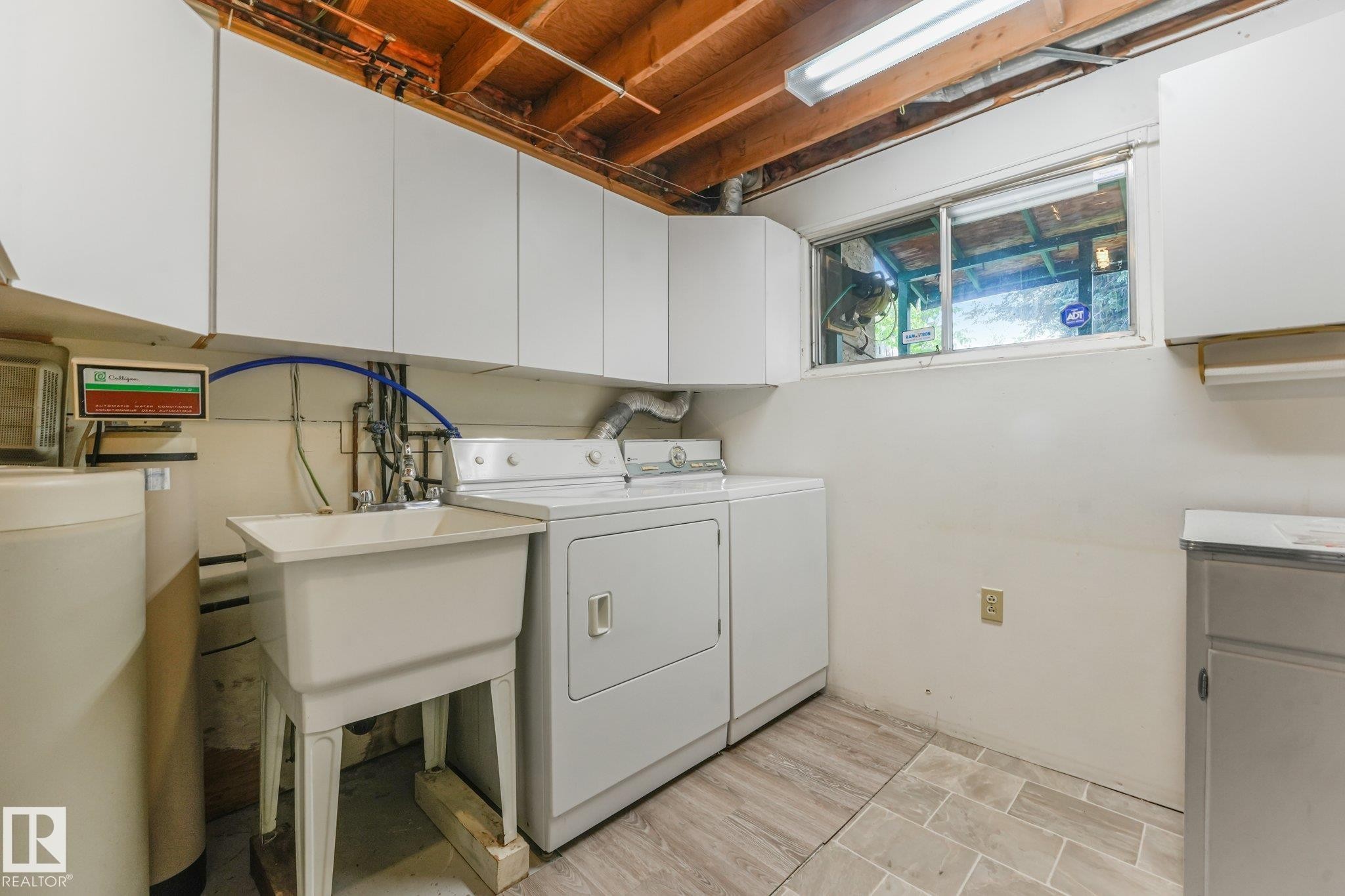 Dedicated utility area featuring a utility sink, washer and dryer, and overhead cabinetry - 4135 134 Avenue Nw, Edmonton, AB - Indoor Photo Showing Laundry Room