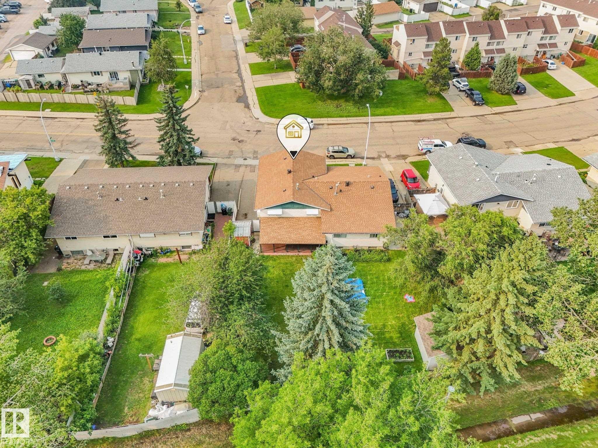 Aerial perspective of a property featuring a residential structure with a brown shingle roof, surrounded by mature trees and green landscaping - 4135 134 Avenue Nw, Edmonton, AB - Outdoor With View