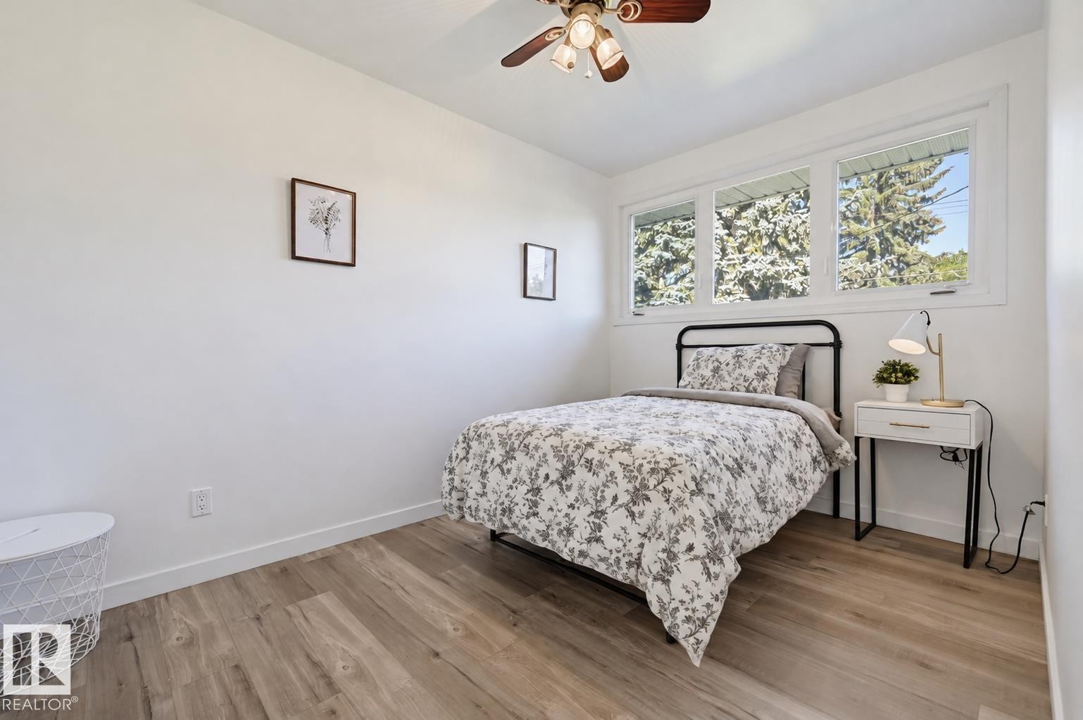 Wood-finish flooring with white baseboards - 9127 149 Street Nw, Edmonton, AB - Indoor Photo Showing Bedroom
